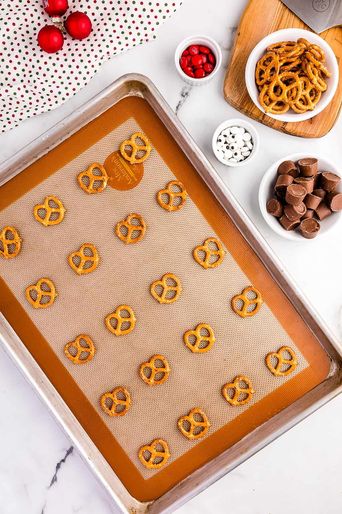 Put Parchment paper onto a Cookie Sheet and place 20 Pretzels onto it.