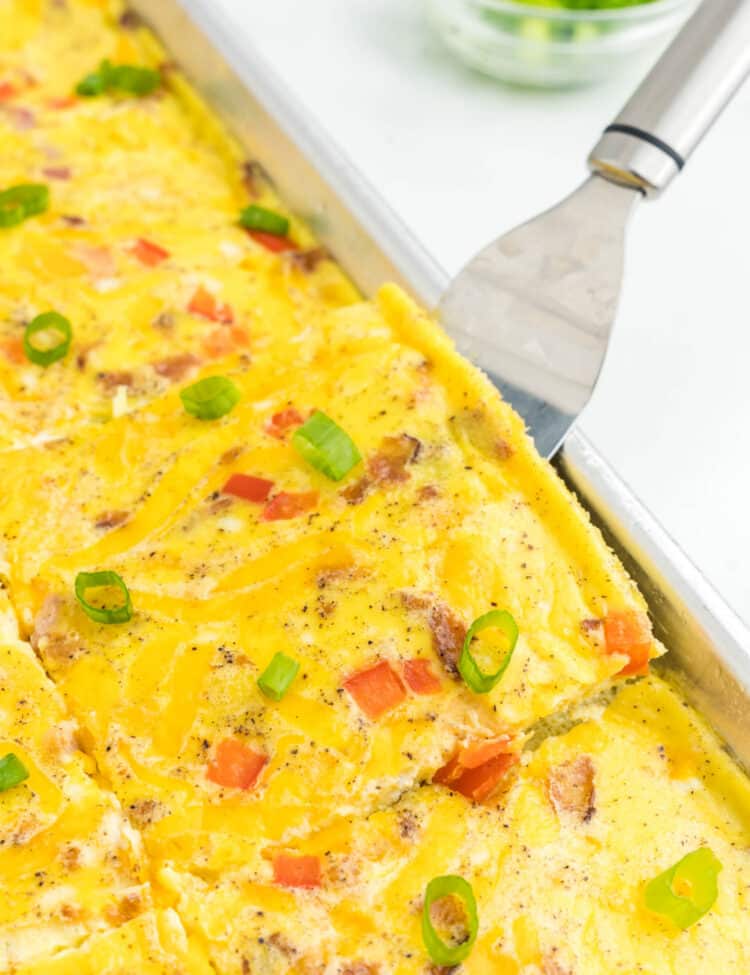 Sheet Pan Eggs cut into square in shallow baking pans with metal spatula