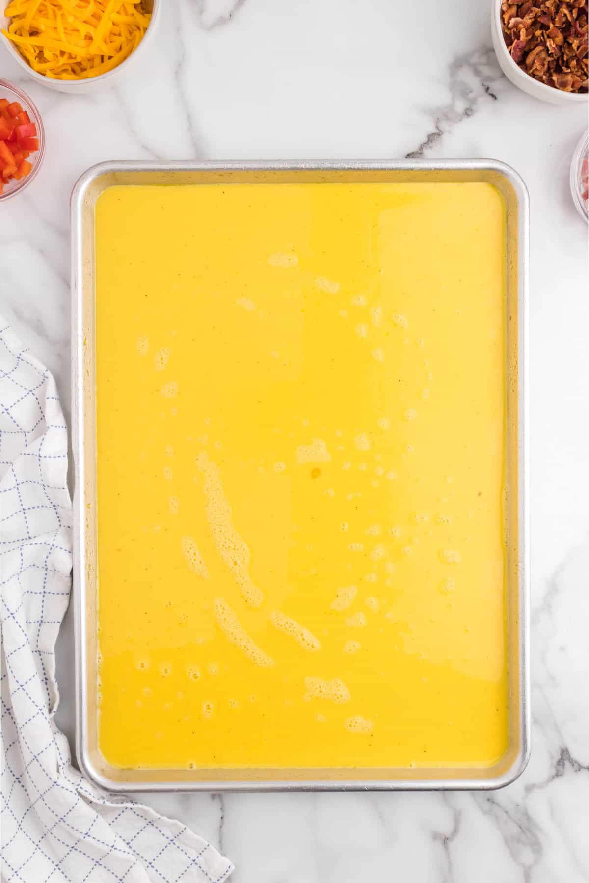 Egg mixture poured into sheet pans for Sheet Pan Eggs