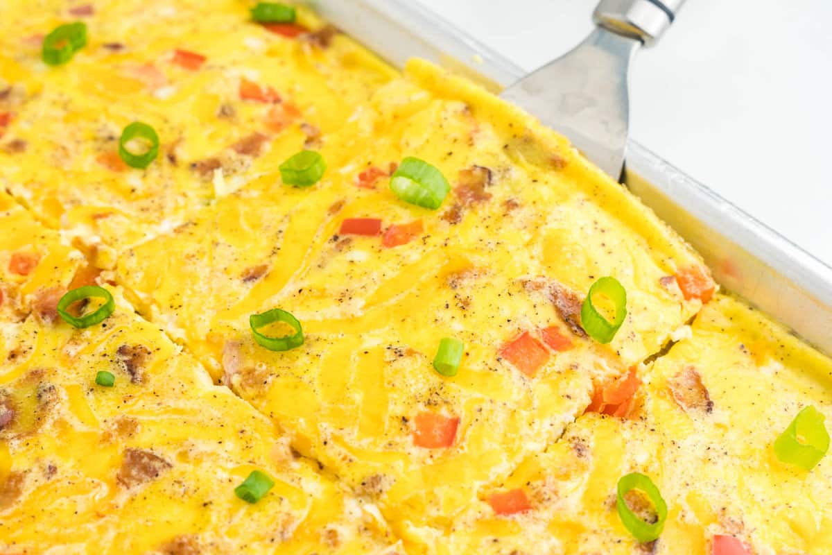 Sheet Pan Eggs cut into square in shallow baking pans with metal spatula