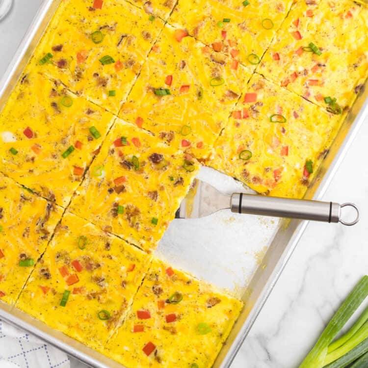 Sheet Pan Eggs cut into square in shallow baking pans with metal spatula