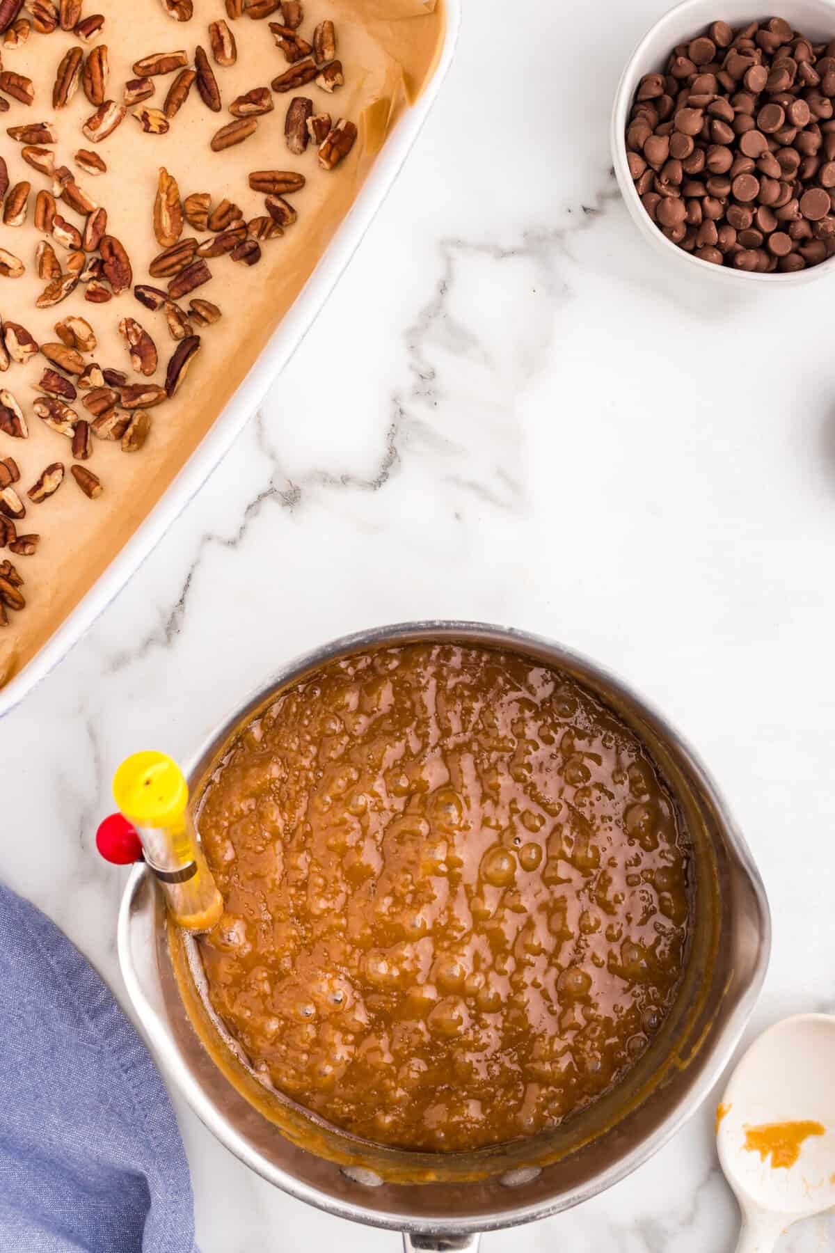 Constantly stirring Toffee ingredients in heavy bottomed sauce pan with candy thermometer attached