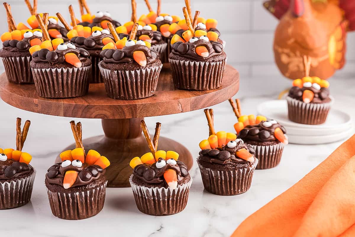 Reindeer Cupcakes displayed on a wooden cupcake stand with cupcakes sitting on the table below it.