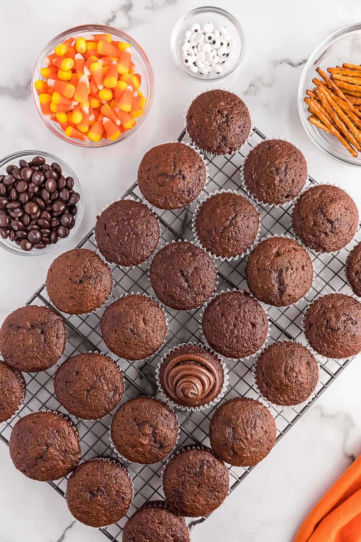 Put the fudge frosting into a piping bag and cut the end of it. Pipe frosting onto the cupcake making the center higher than the rest of the cupcake.