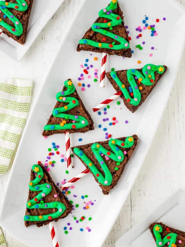 Christmas Tree Brownies displayed on a White plate with sprinkles.