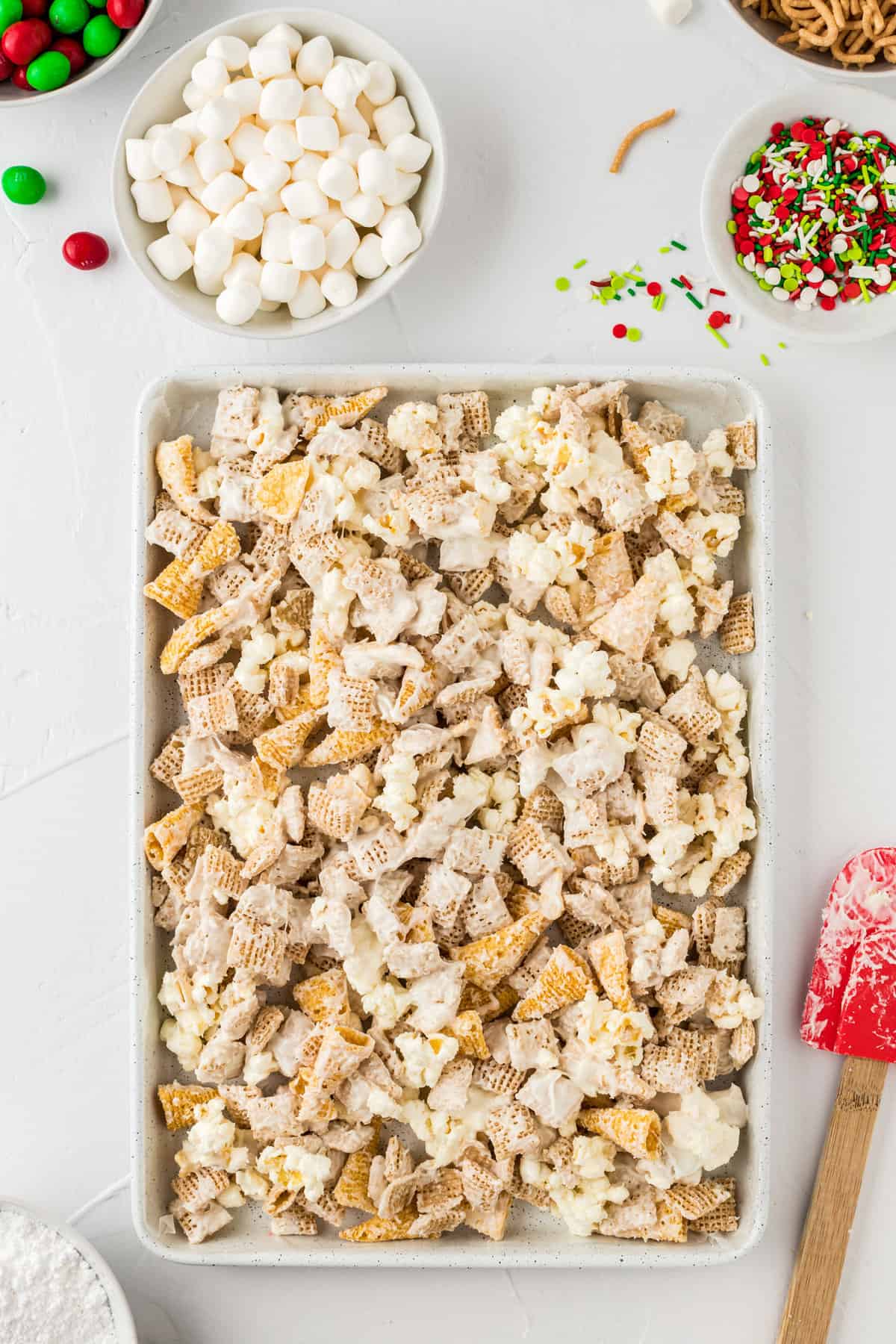 Line a baking sheet with parchment paper & spread out the white chocolate coated mixture to cool.