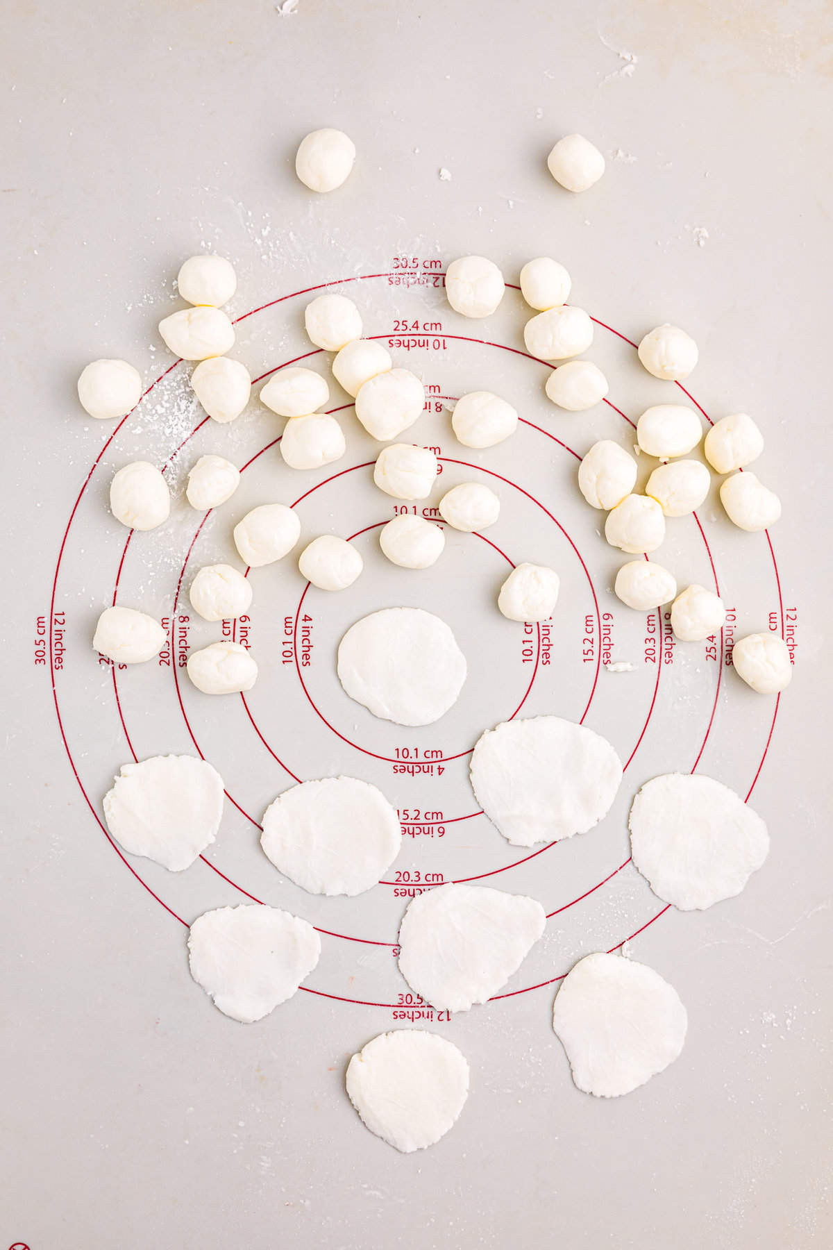 Rolling dough into balls and pressing flat on pastry sheet for Chocolate Covered Cherries