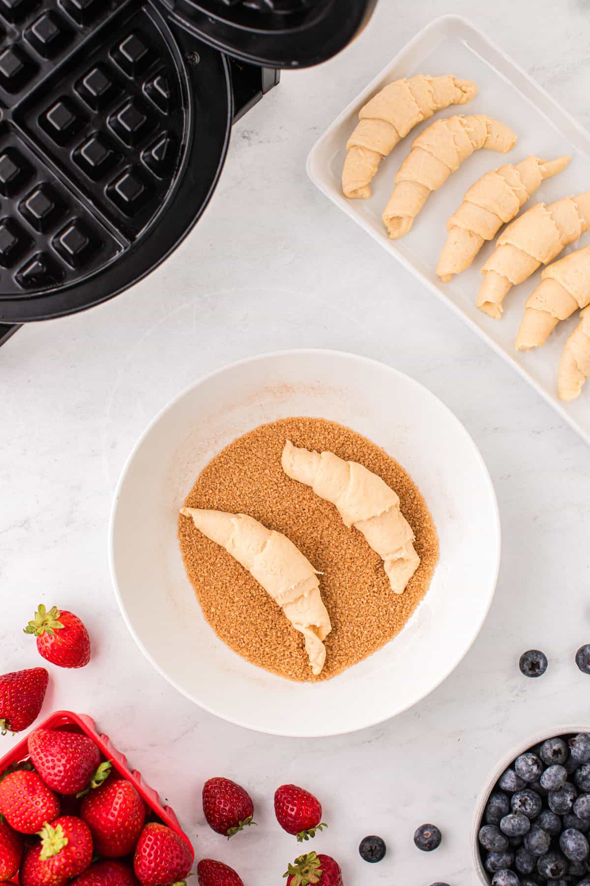 Dip the rolled crescent rolls into the mixed cinnamon and sugar.