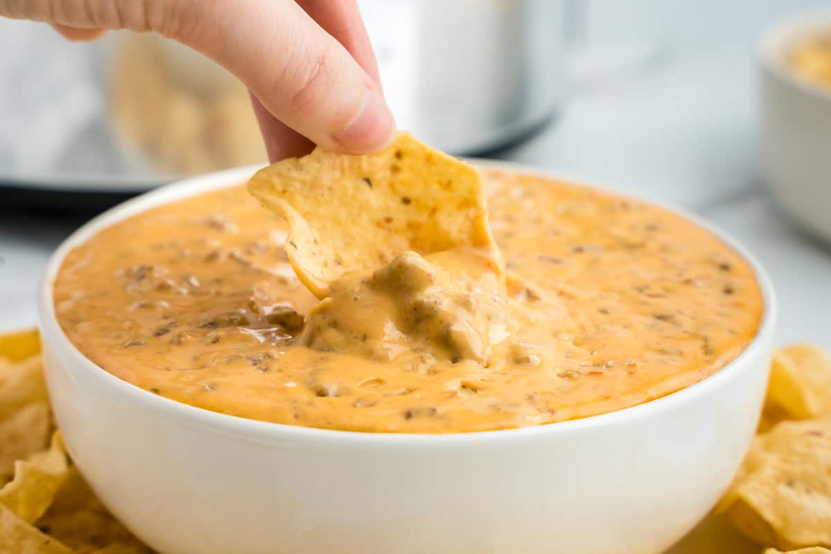 Hamburger Cheese Dip in Bowl with Chip Scooping the First Bite