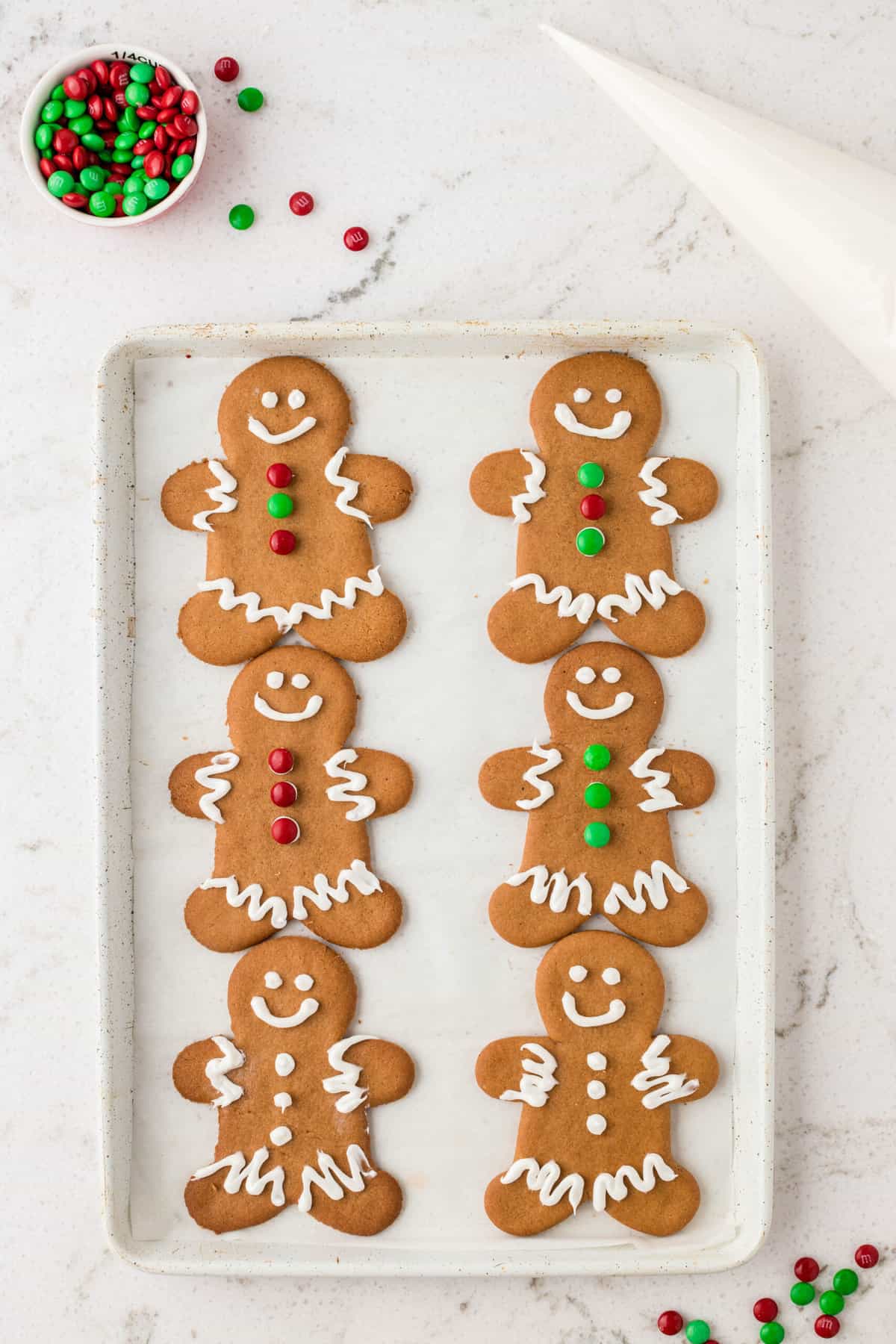 Place the frosting mixture into a piping bag and decorate the gingerbread cookies how you like .