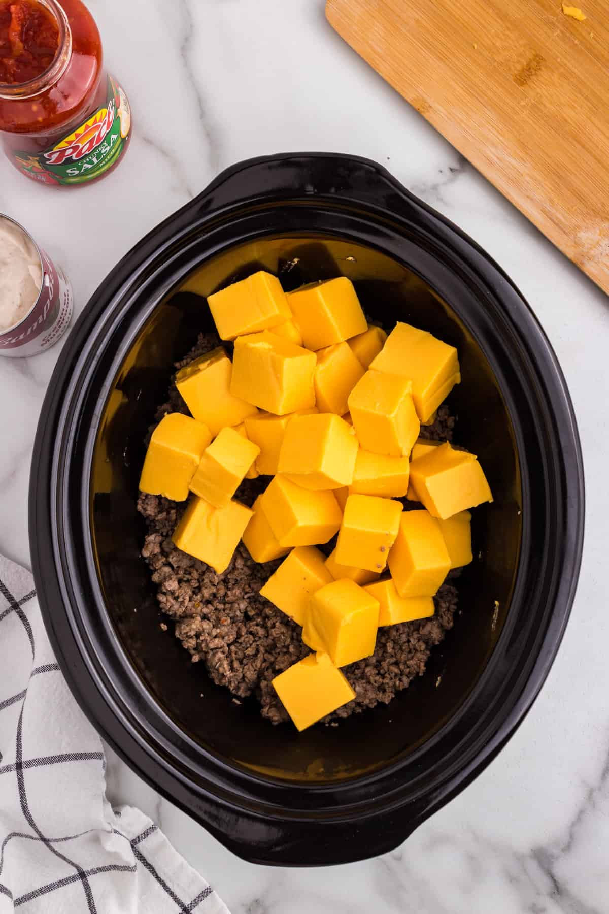 Browned meat and cubed Velveeta cheese in crock pot for Hamburger Cheese Dip