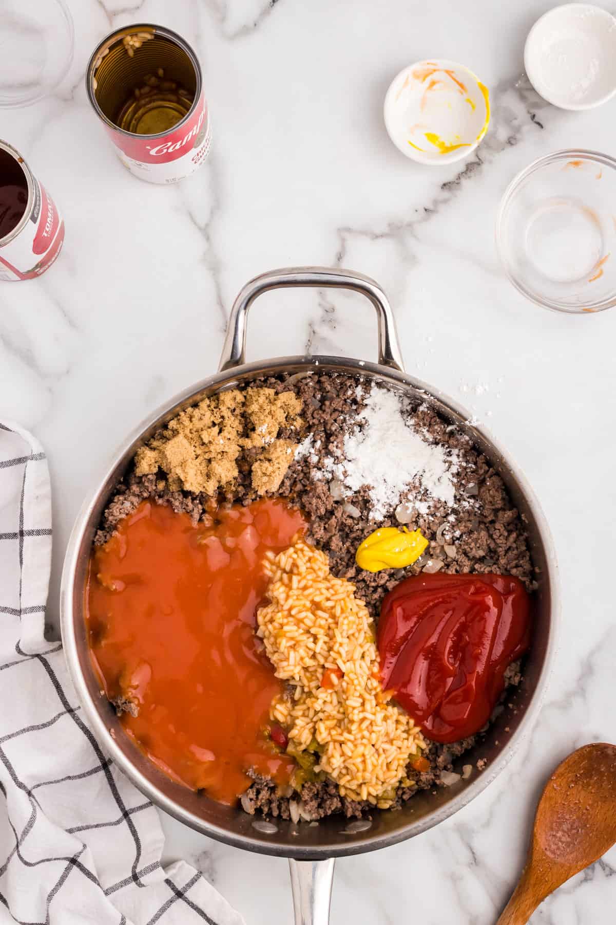 Adding sloppy joe ingredients to browned ground beef in skillet for Large Batch Sloppy Joes