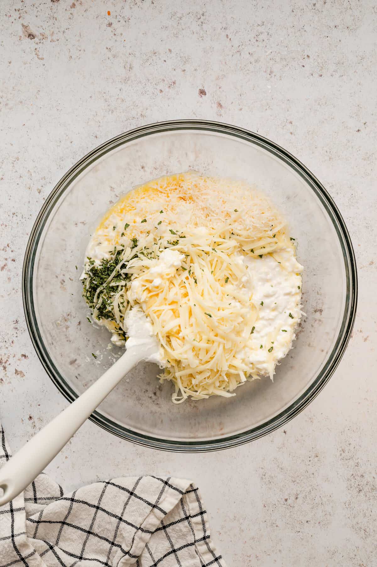 Combining ingredients for Lasagna Casserole in a mixing bowl with large spoon