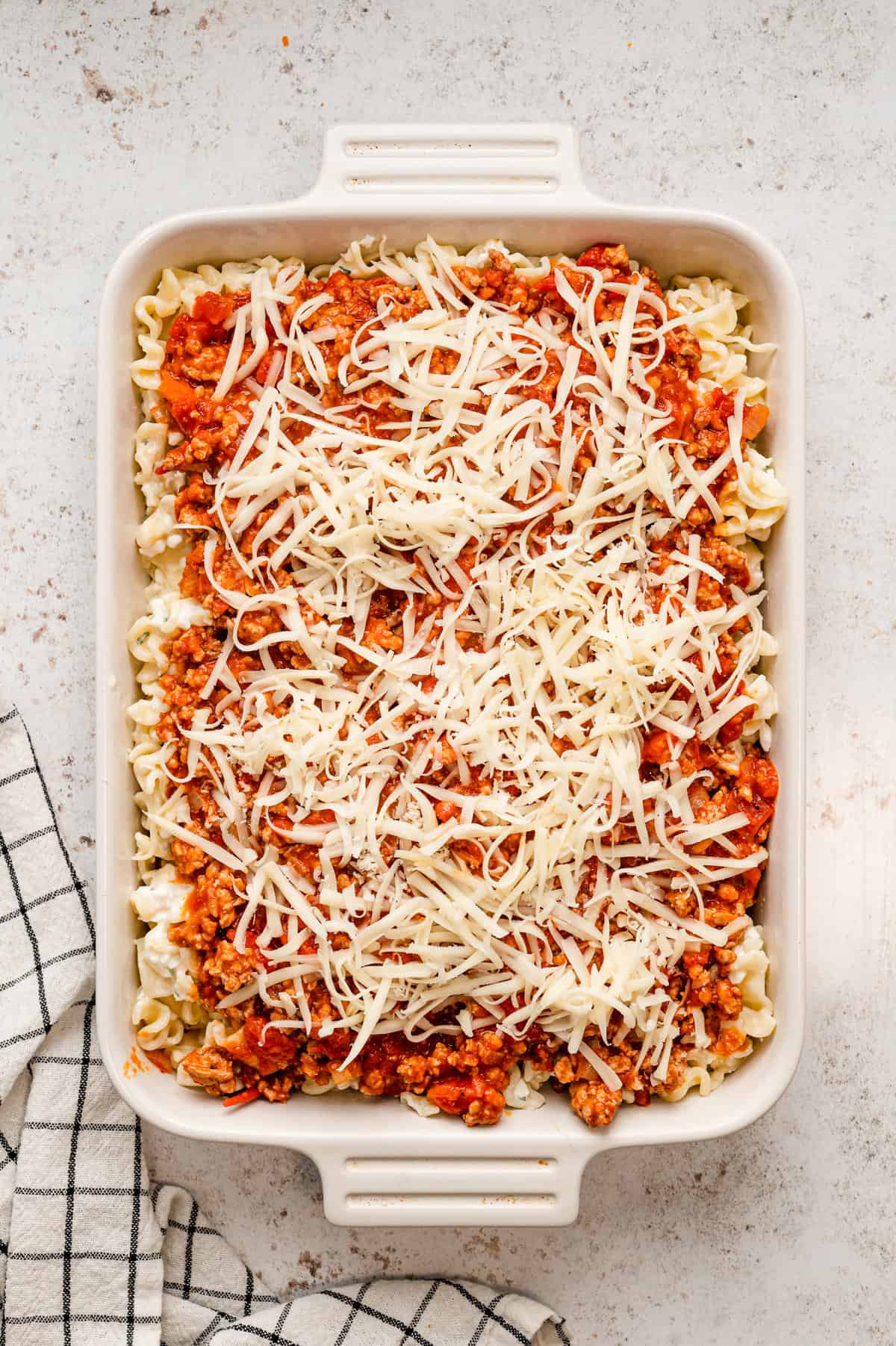 Adding shredded cheese to Lasagna Casserole before baking