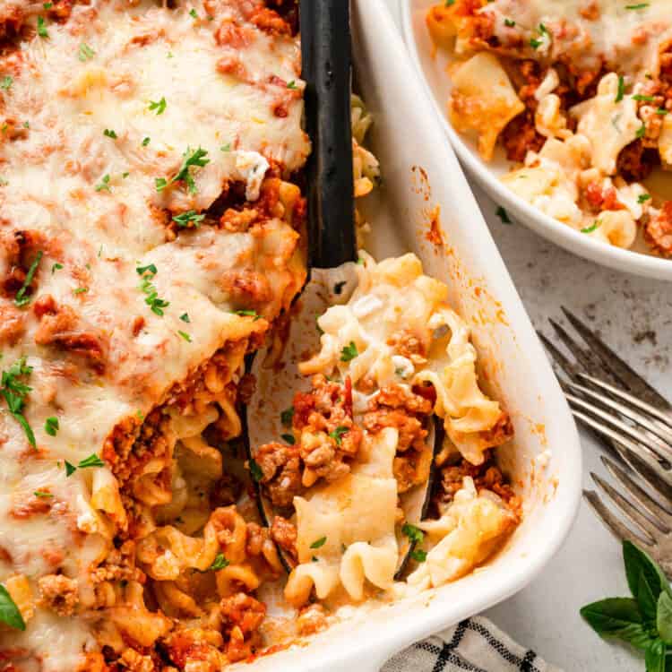 Square Image of Lasagna Casserole being scooped out of baking dish