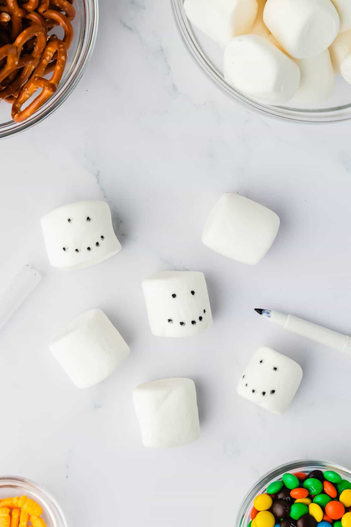 Take a Food Marker and put Dots for Eyes and a Mouth on the Marshmallows.