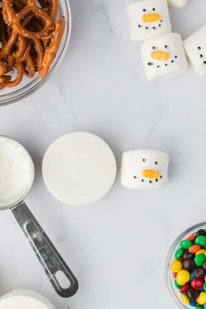 Using leftover Chocolate attach the Marshmallow to the Cookie for the Snowman Head.