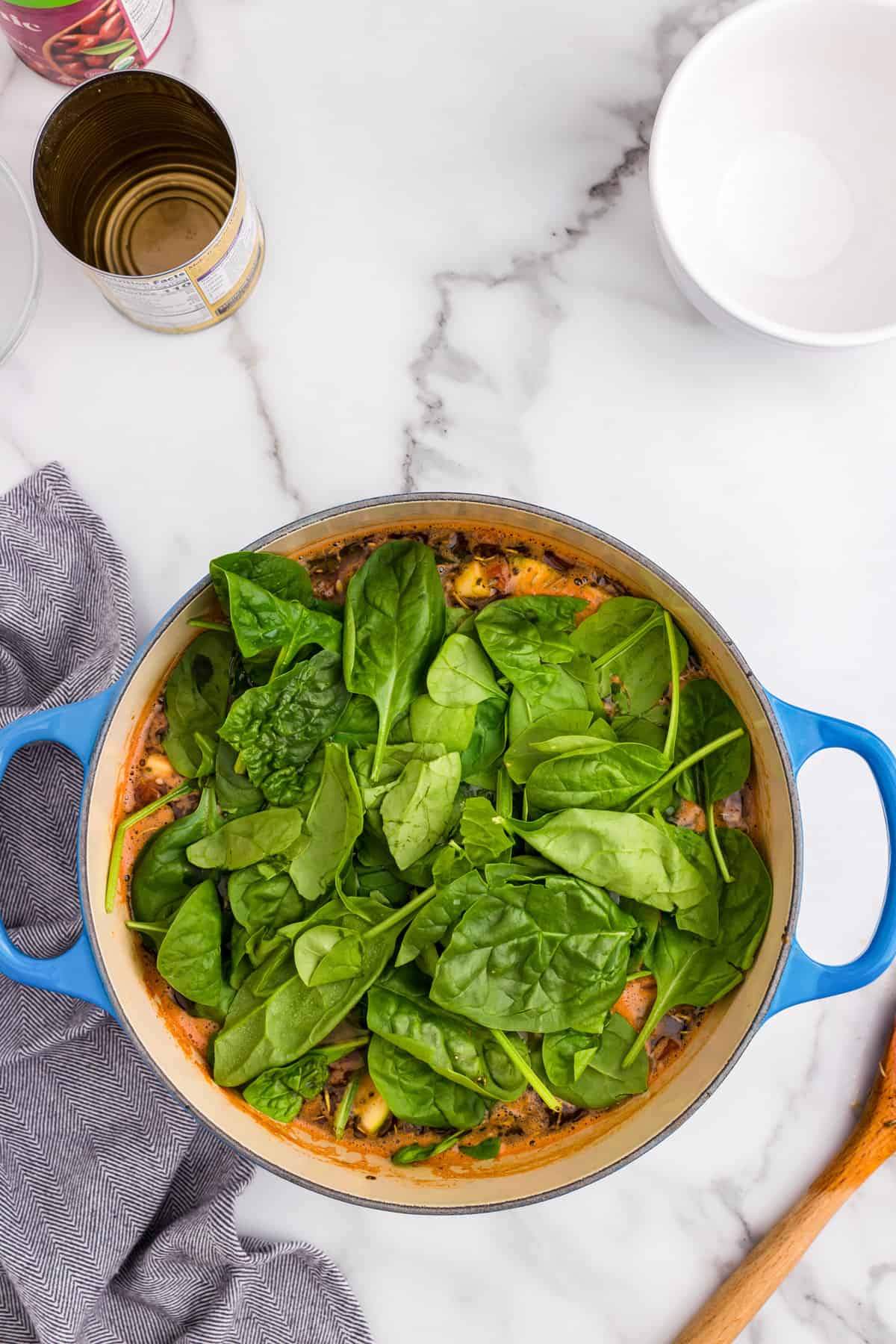 Adding fresh spinach to Olive Garden Minestrone Soup in large pot