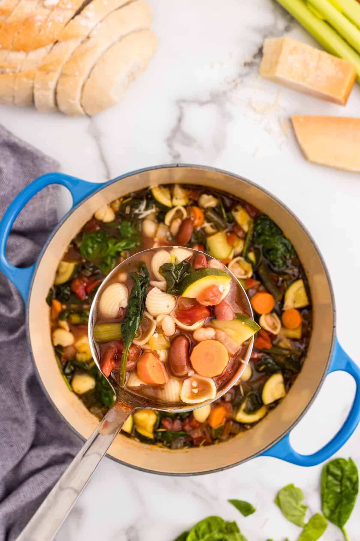 Using large laddle to scoop Minestrone Soup from dutch oven