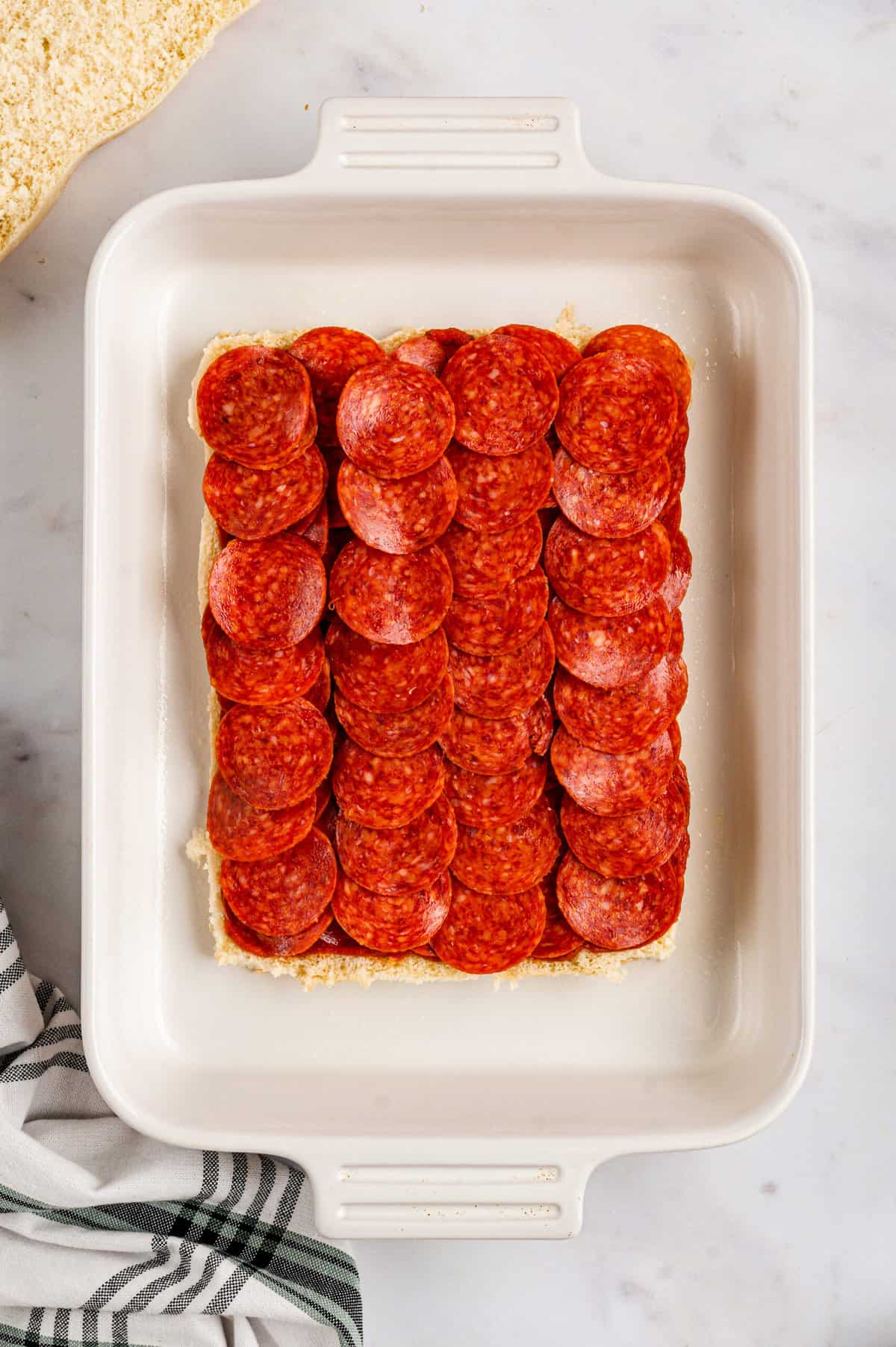 Arranging pepporoni slices atop pizza sauce for Pizza Sliders recipe