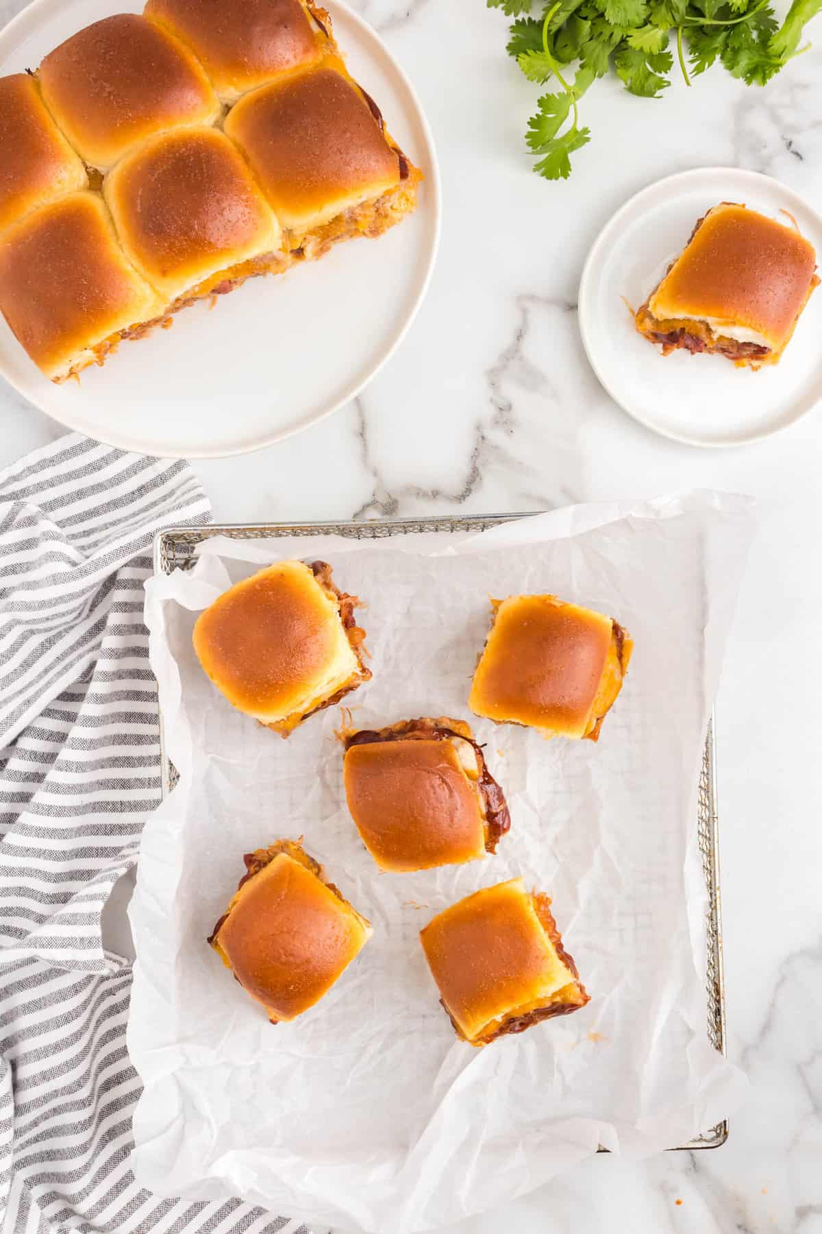 Pulled apart Leftover Pulled Pork Sliders on baking sheet and on plate