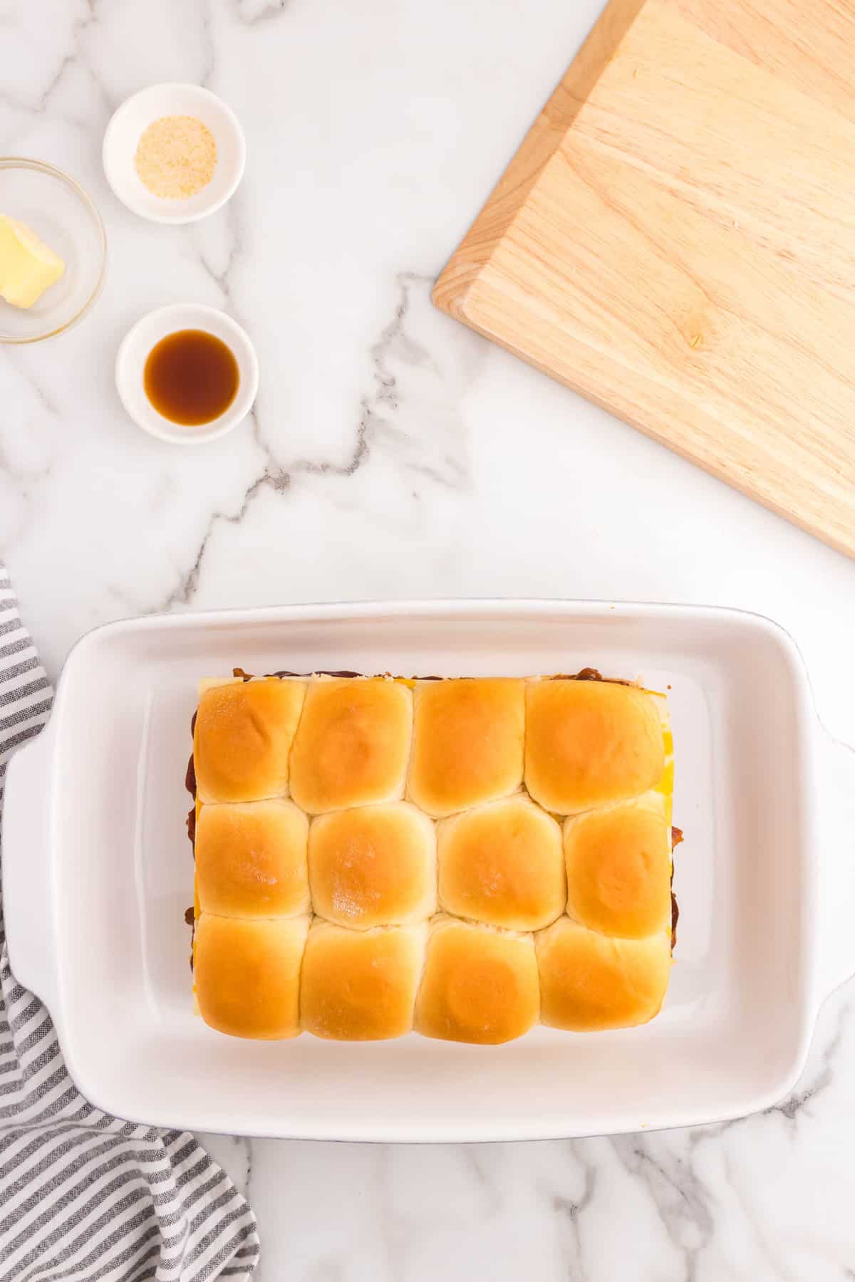 Covering sliders with the top sliced half of Hawaiian buns for Leftover Pulled Pork Sliders