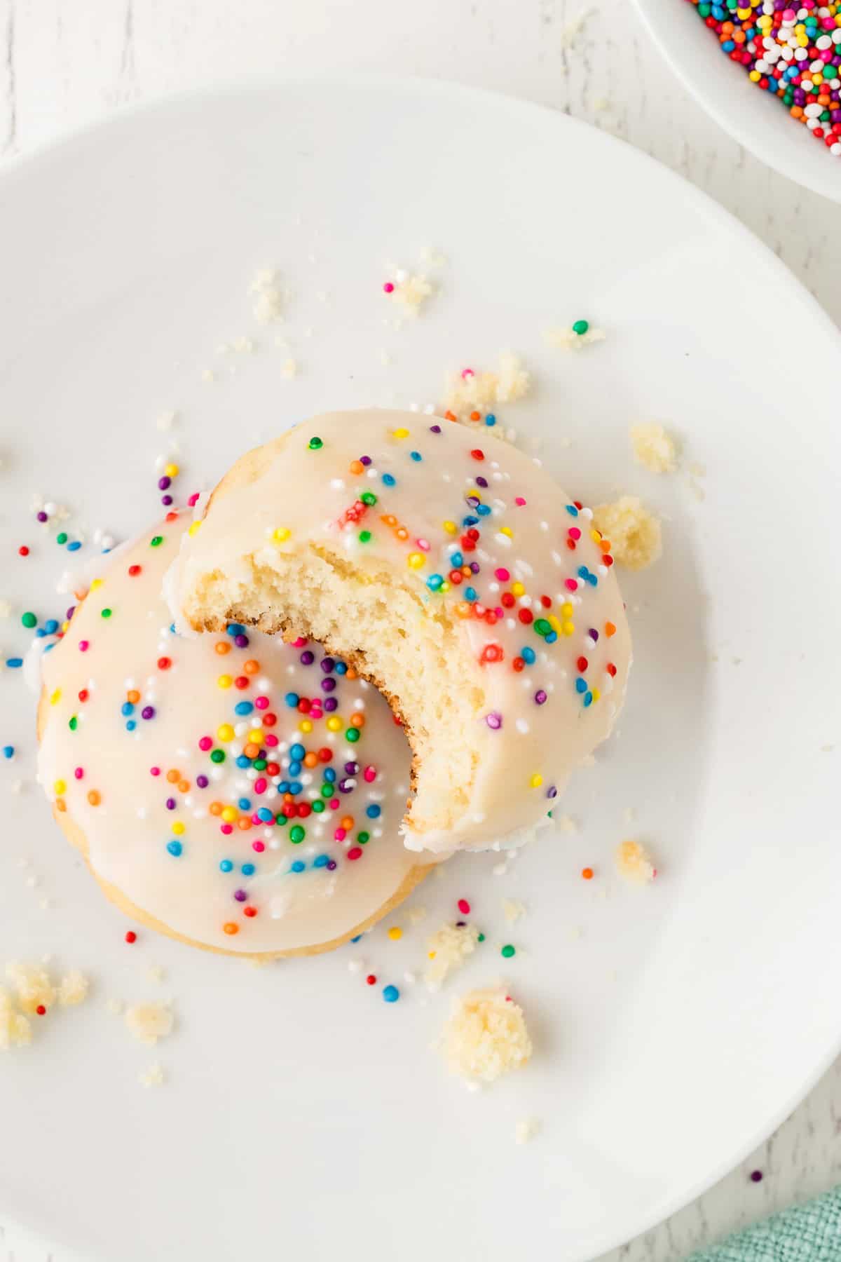 Two Cookies stacked on top of each other with the top one having a bite taken out of it.