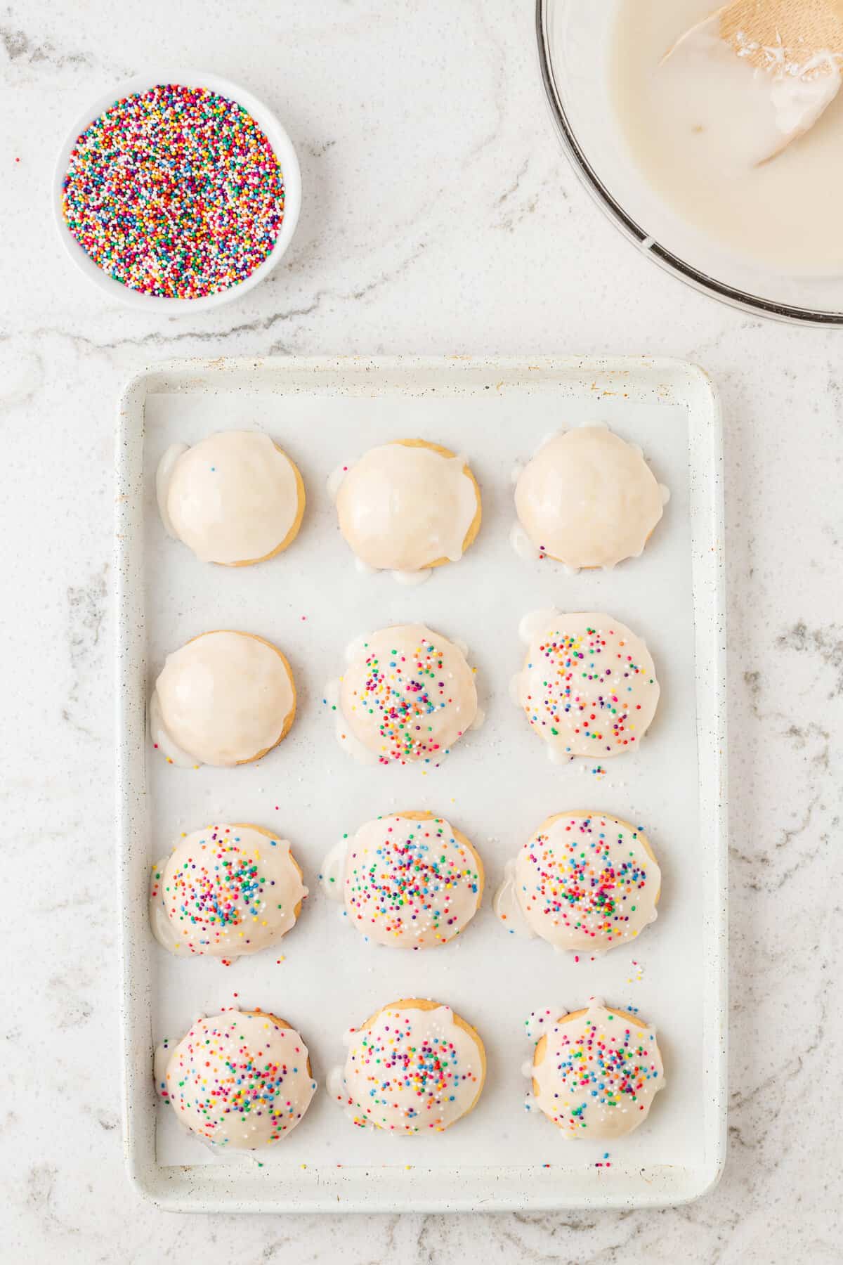 Dip the top of each cookie into the glaze and place them back onto the cookie sheet and had sprinkles to the top of the glaze.