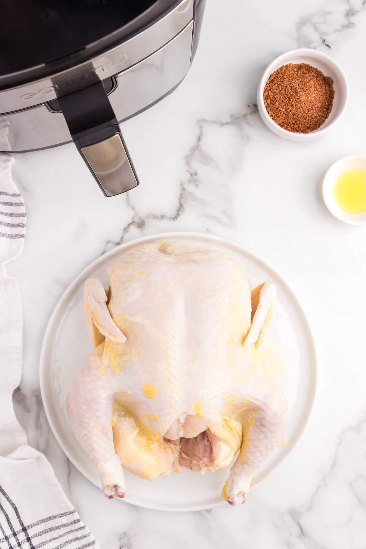 Coating chicken with olive oil for Air Fryer Rotisserie Chicken