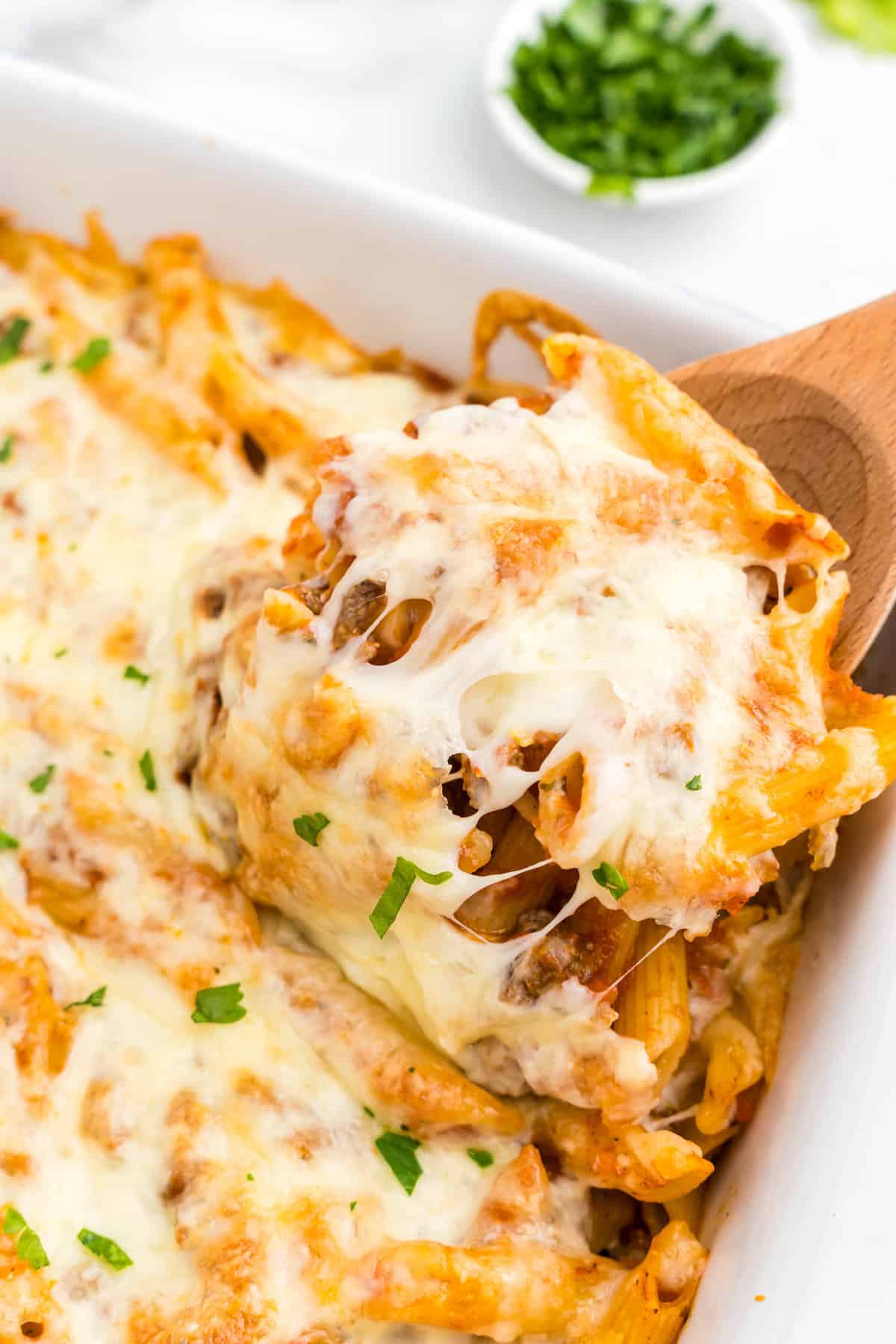 Ground Beef Casserole in baking dish with wooden spoon