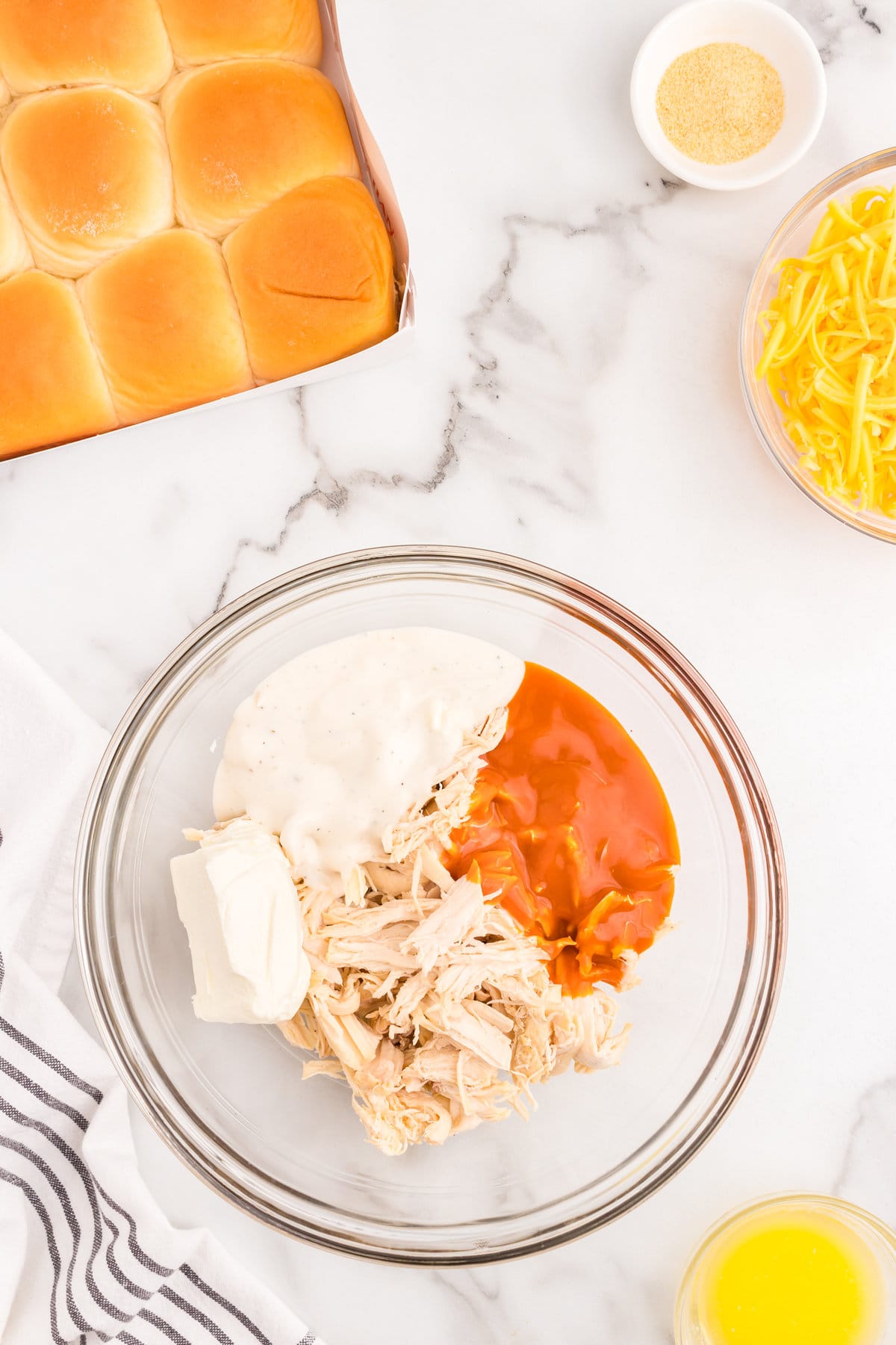 Buffalo Chicken Sliders ingredients in glass mixing bowl