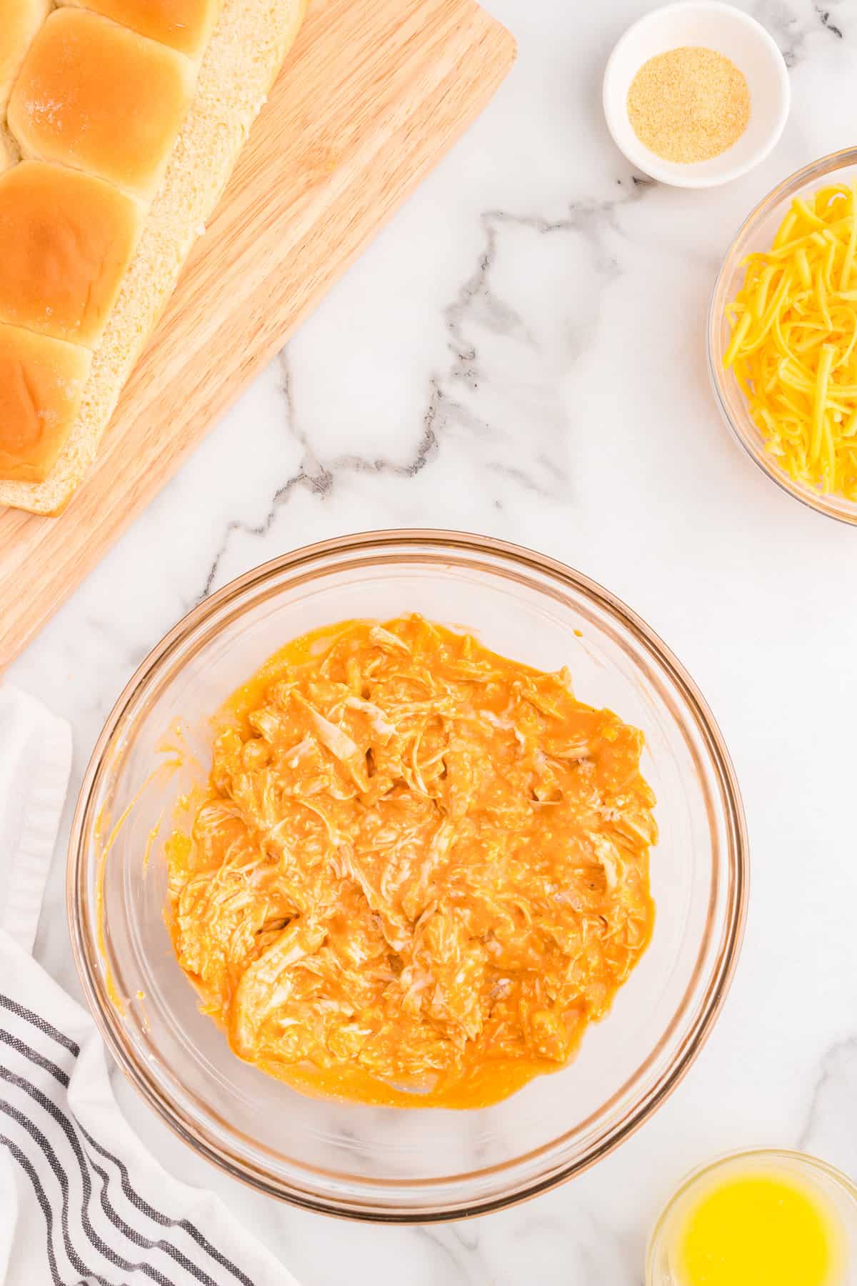 Combined Buffalo Chicken Sliders mixture in glass mixing bowl