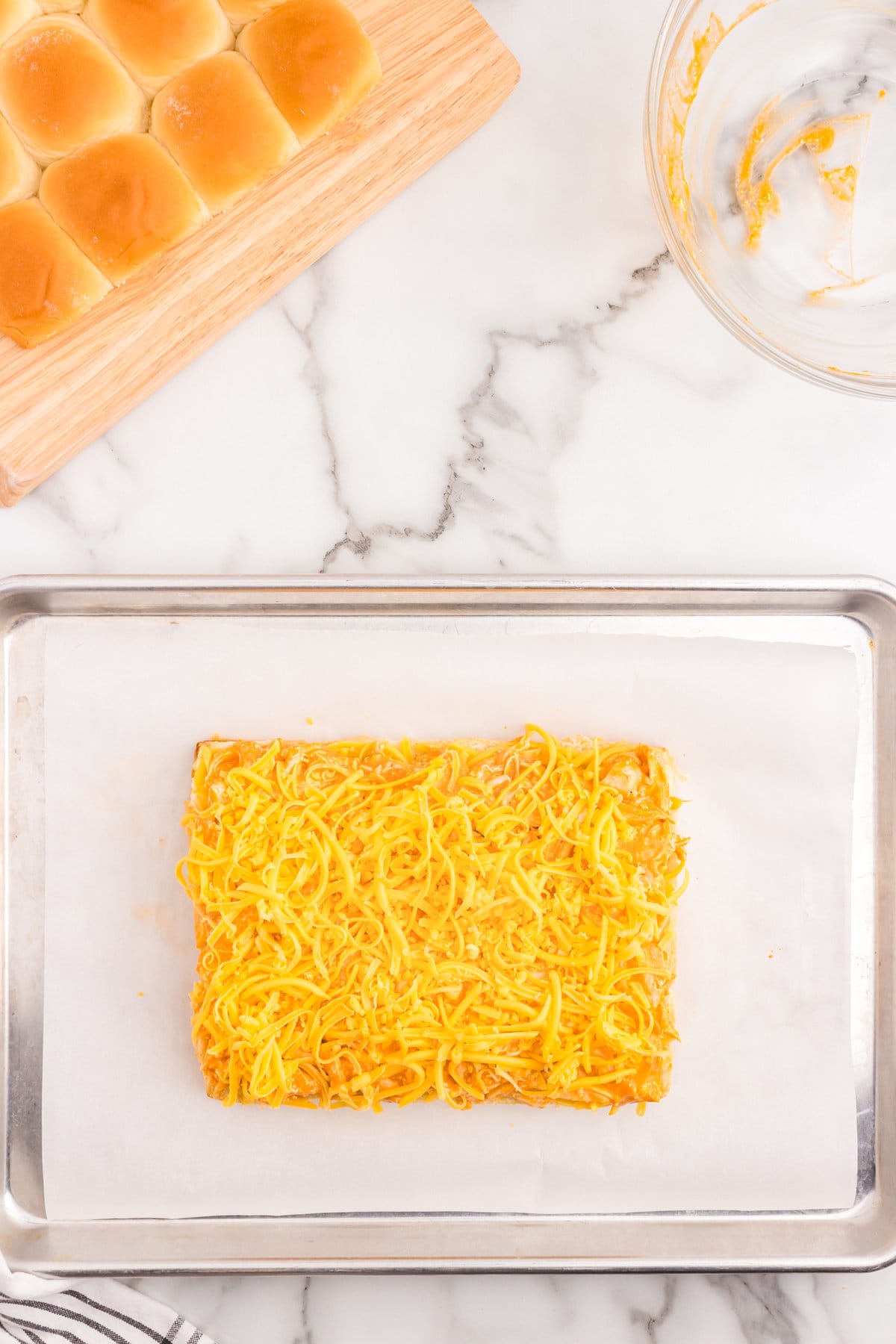 Adding shredded cheese to chicken mixture for Buffalo Chicken Sliders recipe