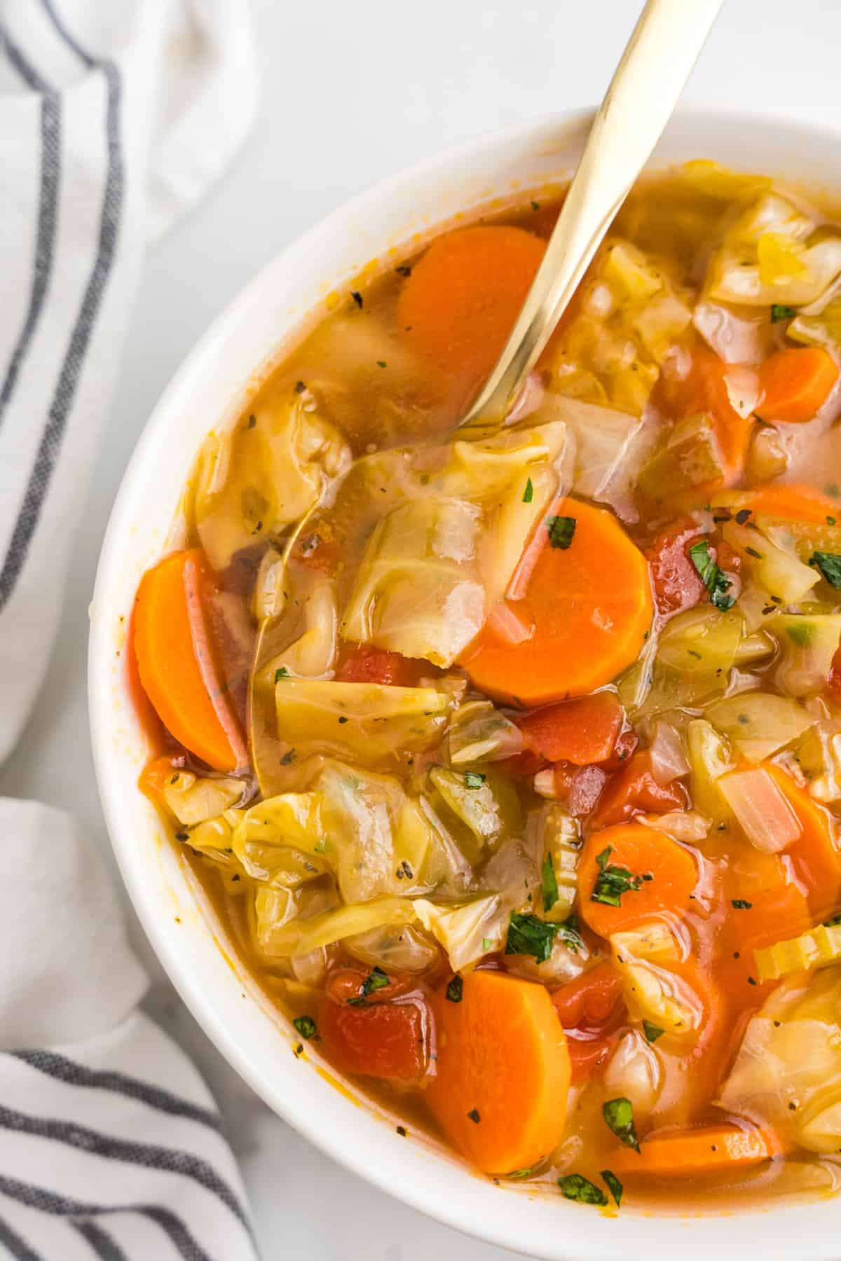 Cabbage Vegetable Soup in bowl with spoon ready to enjoy