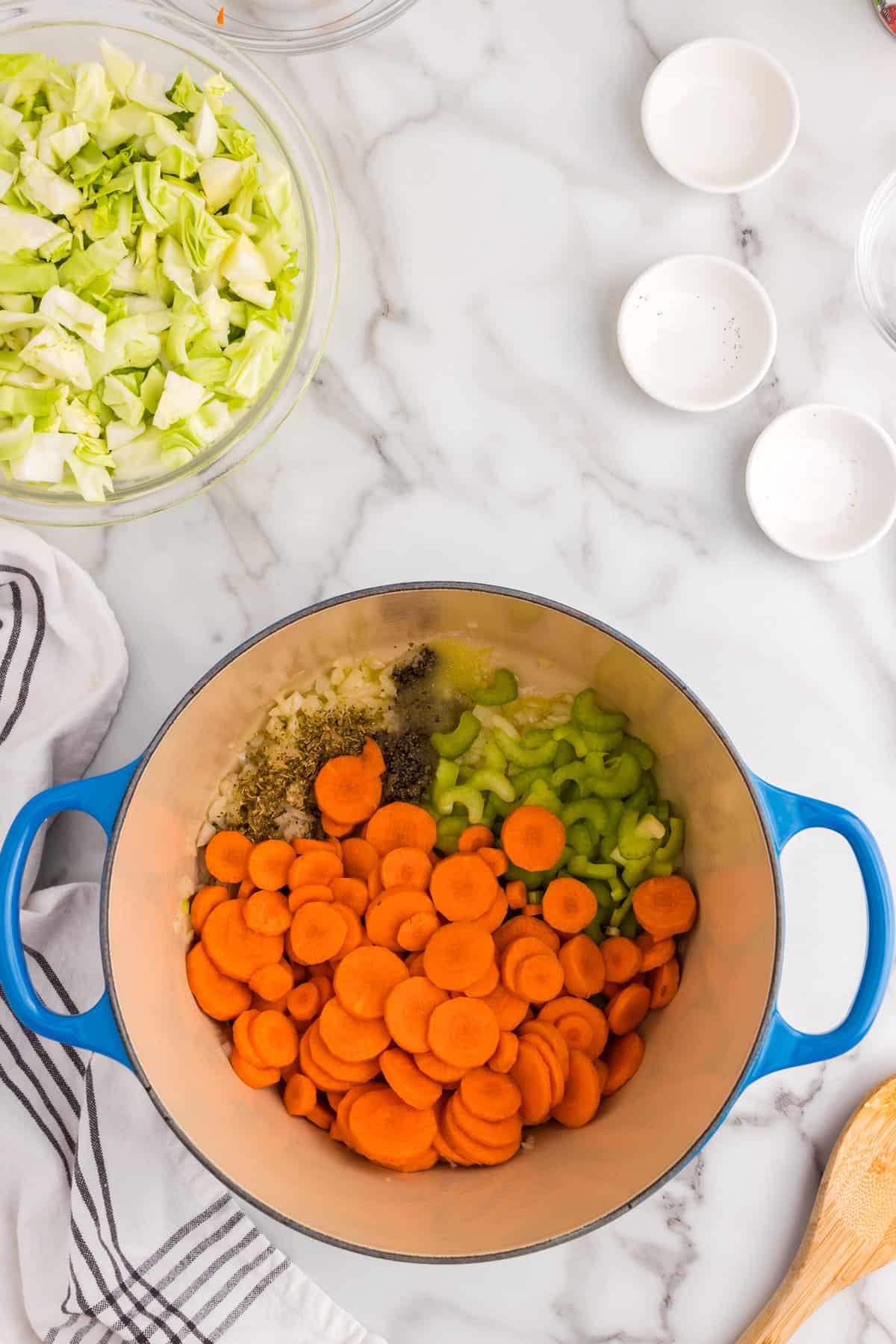 Adding prepared vegetables to Cabbage Vegetable Soup mixture in Dutch Oven