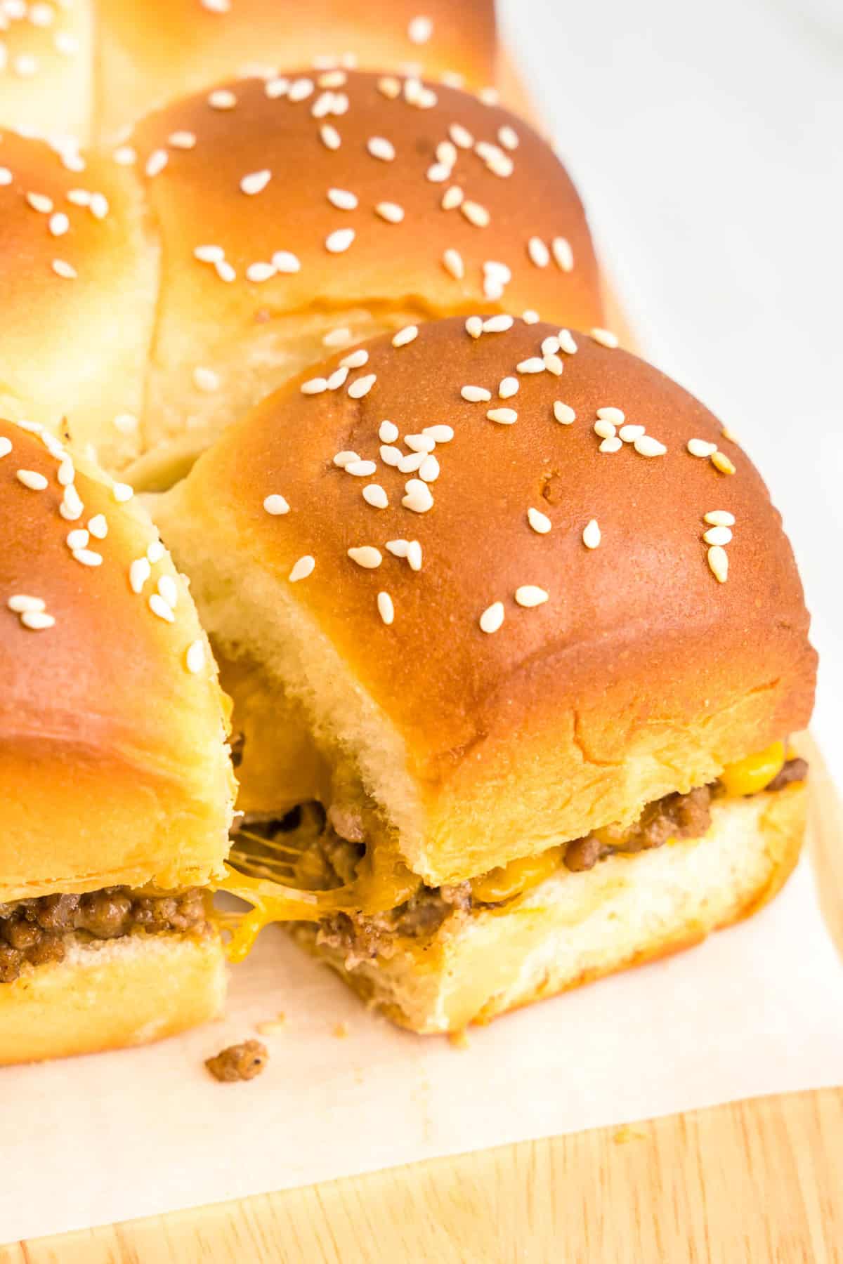 Pulling apart Cheeseburger Sliders hot out of the oven in the baking dish