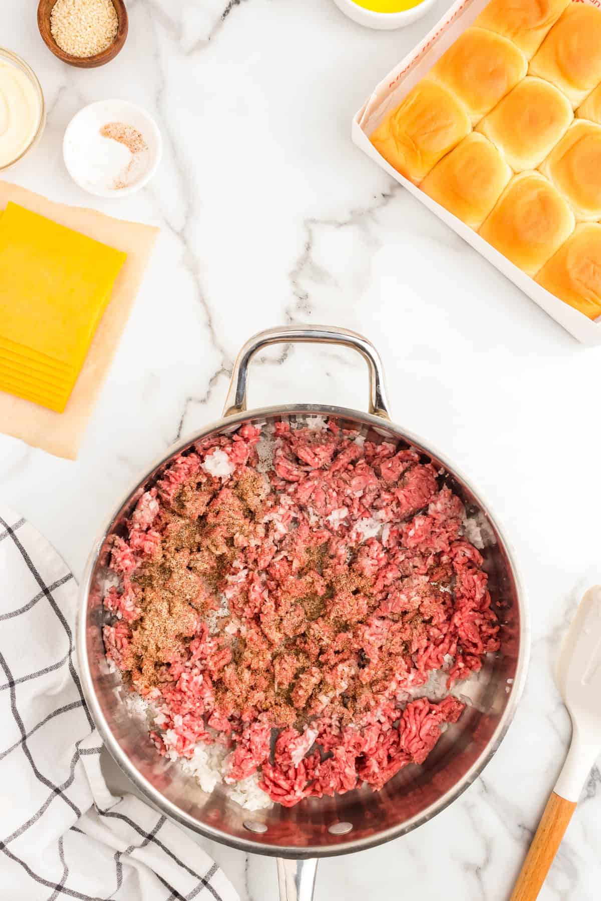 Browning ground beef and seasoning in stovepot skillet for Cheeseburger Sliders recipe