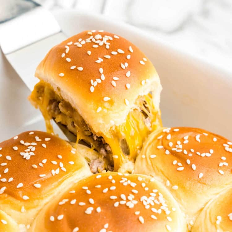 Cheeseburger Sliders in baking pan with metal spatula