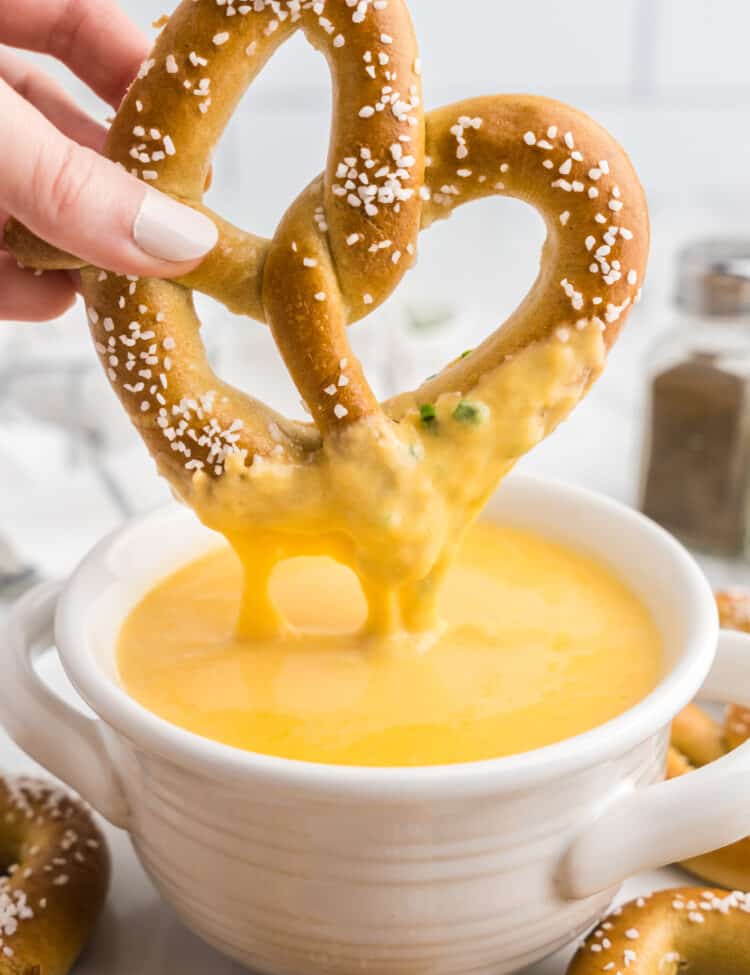 Using homemade pretzel to dip into Beer Cheese Dip in serving bowl