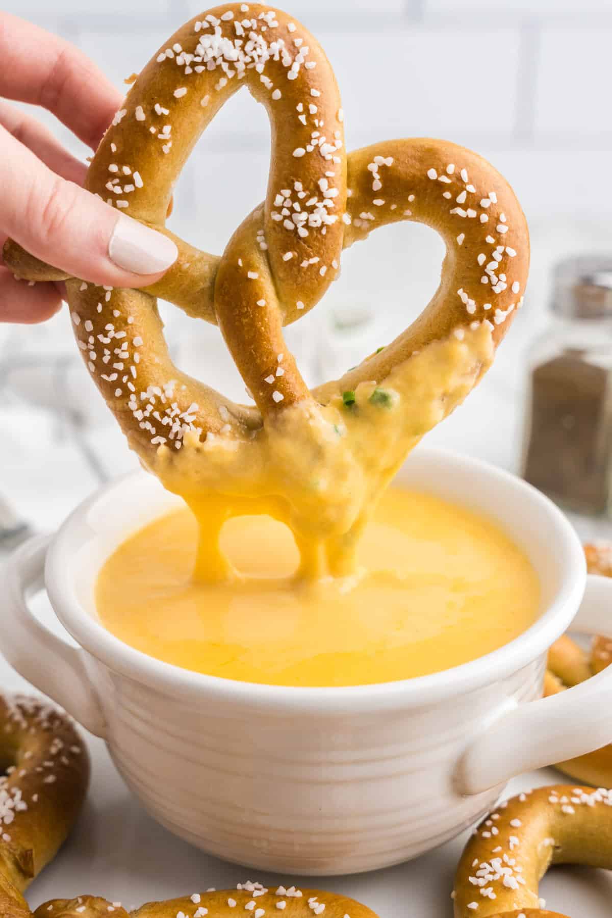 Using homemade pretzel to dip into Beer Cheese Dip in serving bowl