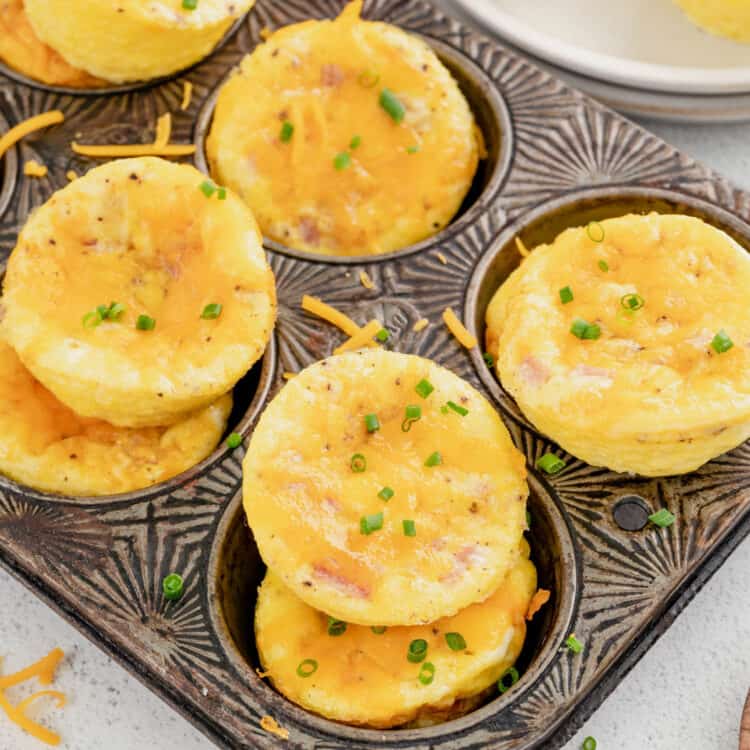 Egg Muffin Cups stacked in muffin tin topped with chives