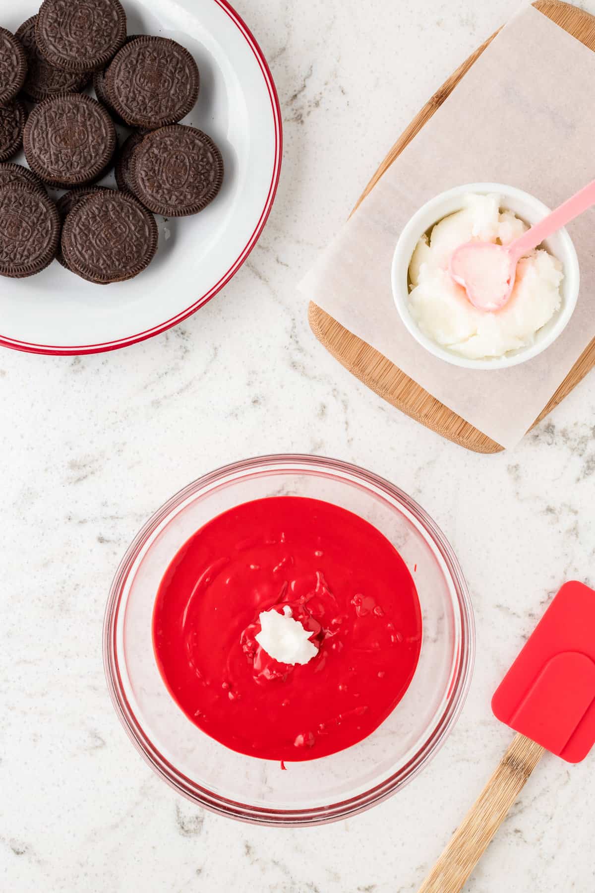 Red candy melt and coconut oil in mixing bowl for Ladybug Oreos