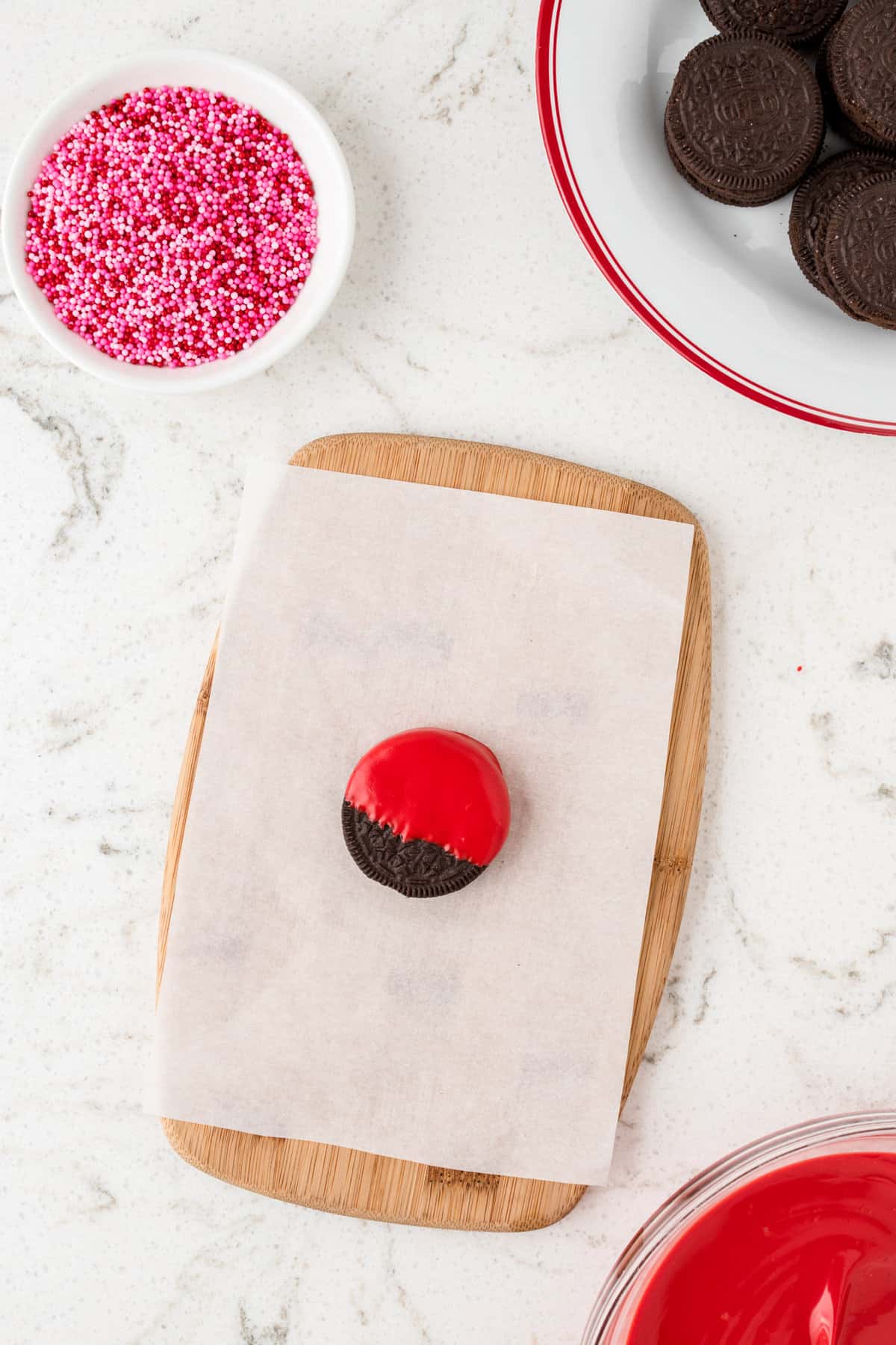 Dipped oreo in red candy melt mixture for Ladybug Oreos