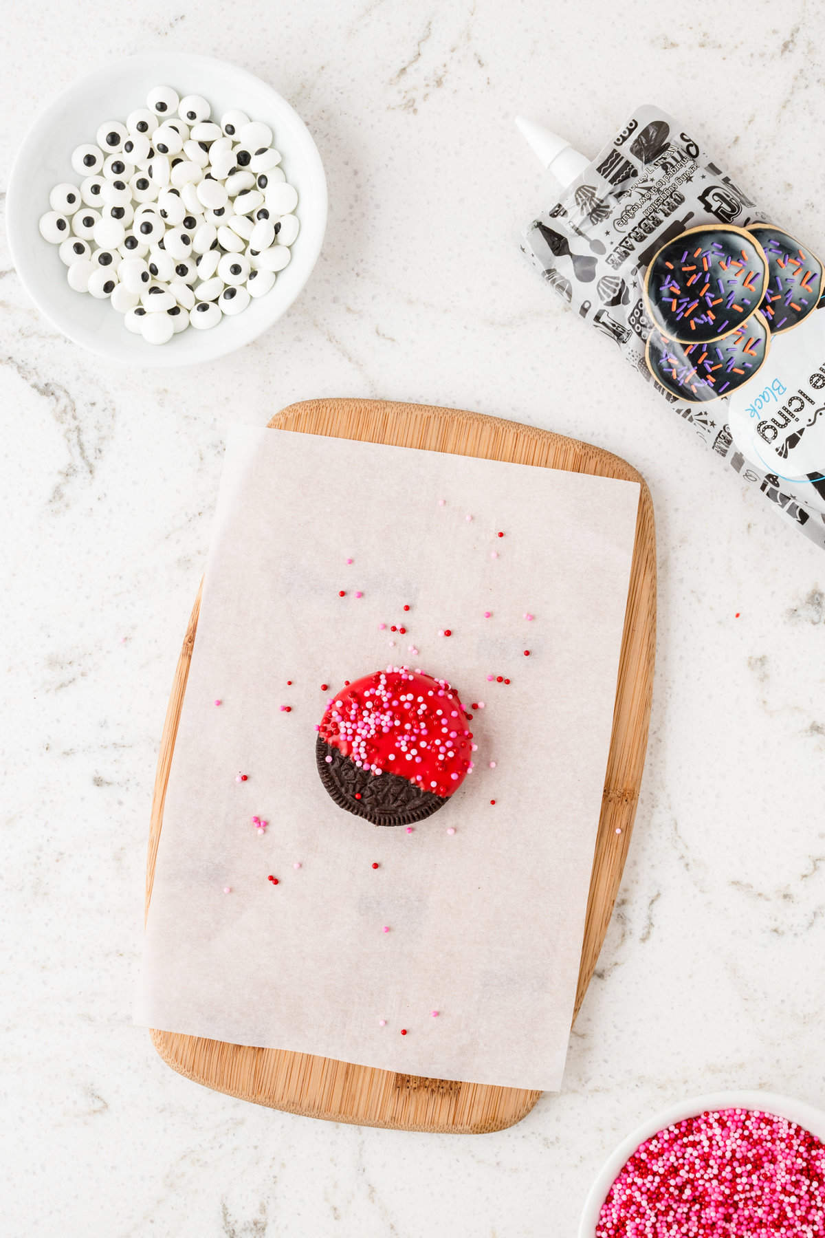 Adding Valentine's sprinkles to dipped oreo