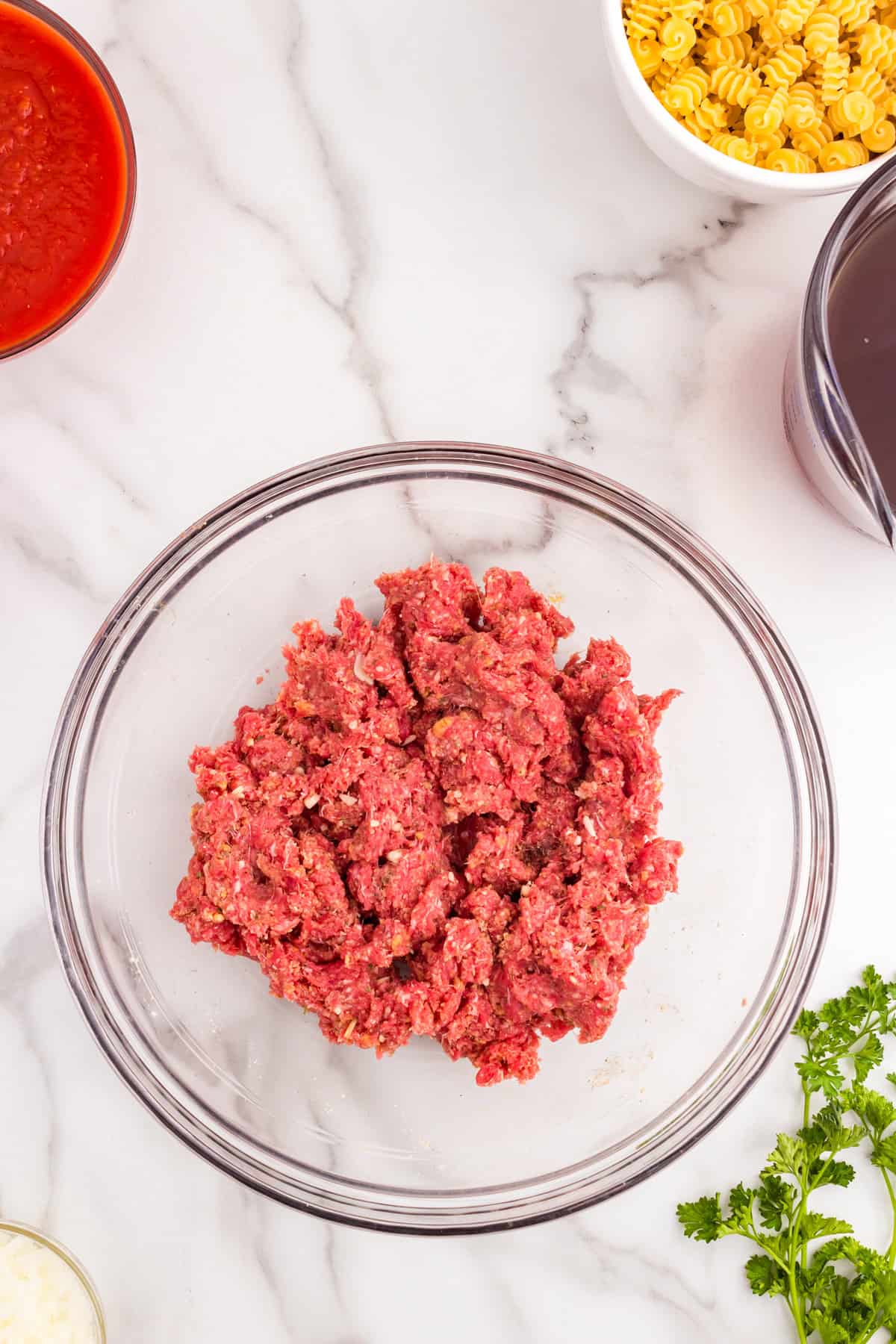 Ground beef and seasonings combined in mixing bowl for meatballs for  Italian Meatball Soup recipe