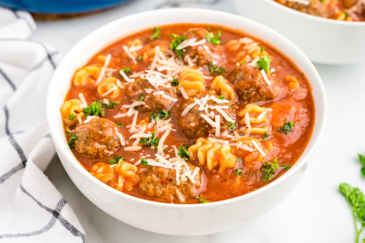 Italian Meatball Soup in bowl topped with fresh parsley and shredded cheese