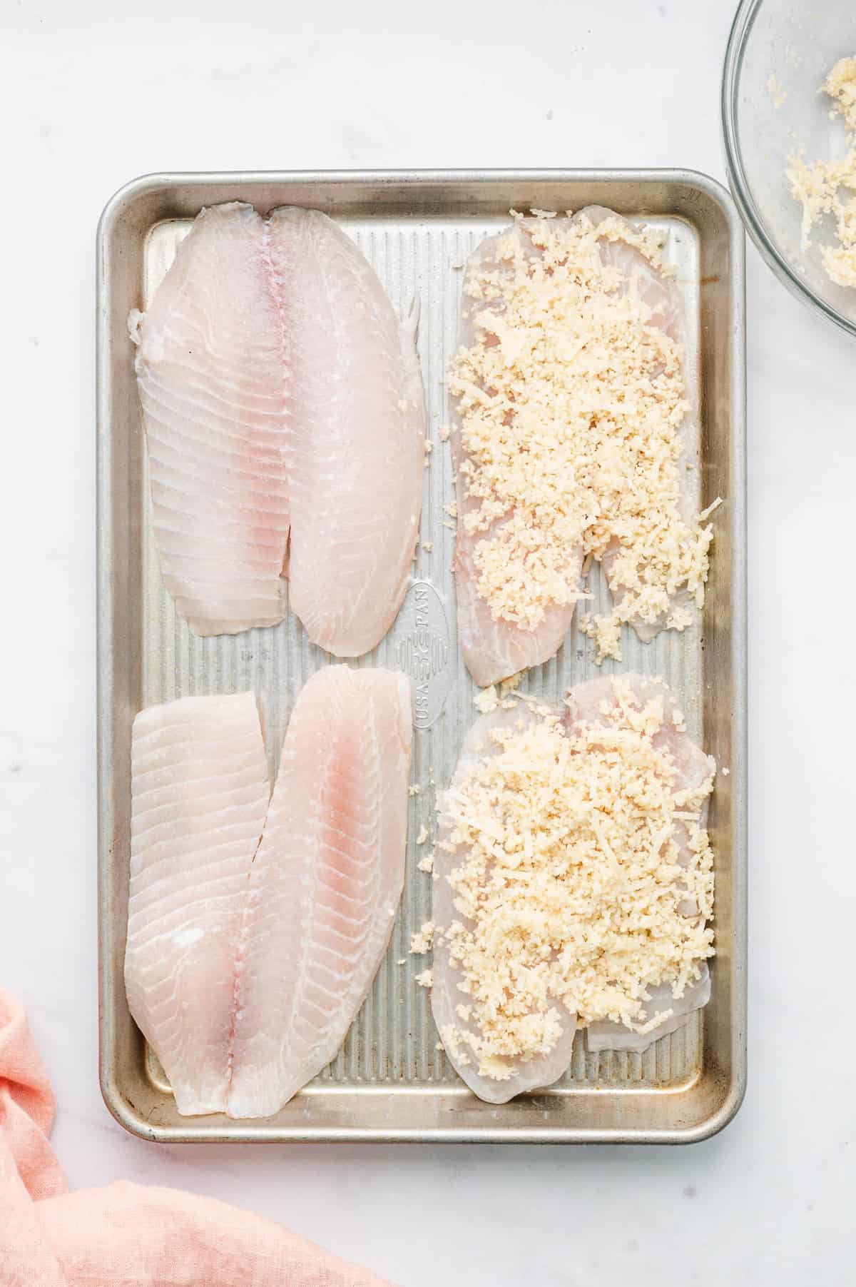 Coating tilapia filets with parmesan mixture on baking sheet for Parmesan Crusted Tilapia recipe