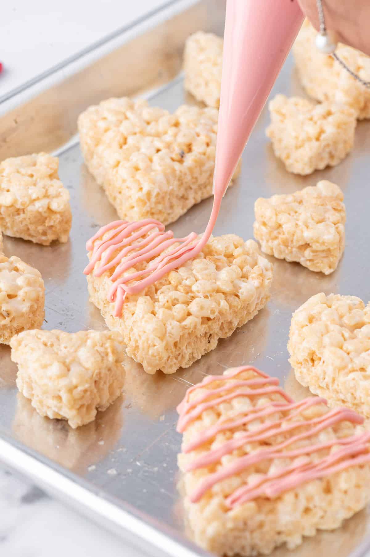 Put melted candies and chips into Piping bags and cut the tip of the bag. Decorate your Hearts as you'd like.