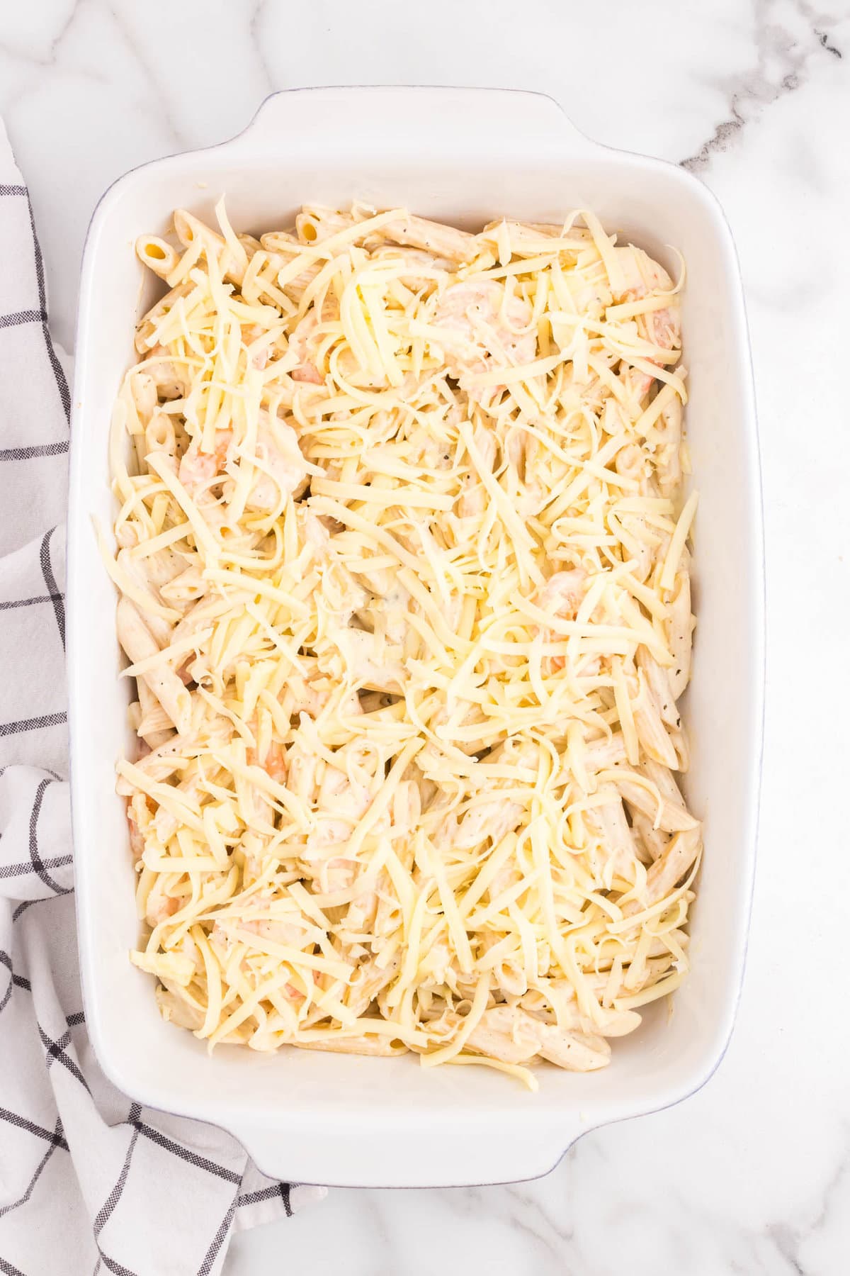 Shrimp Alfredo Bake in 9x13 baking dish topped with cheese