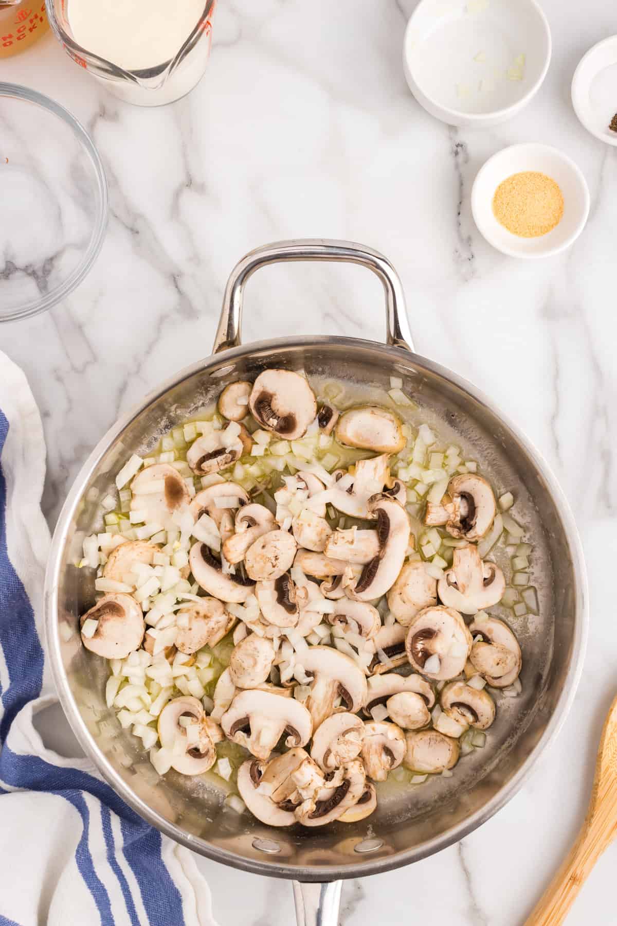 Cooking onion and mushrooms in buttered stovetop skillet for Chicken ala King recipe